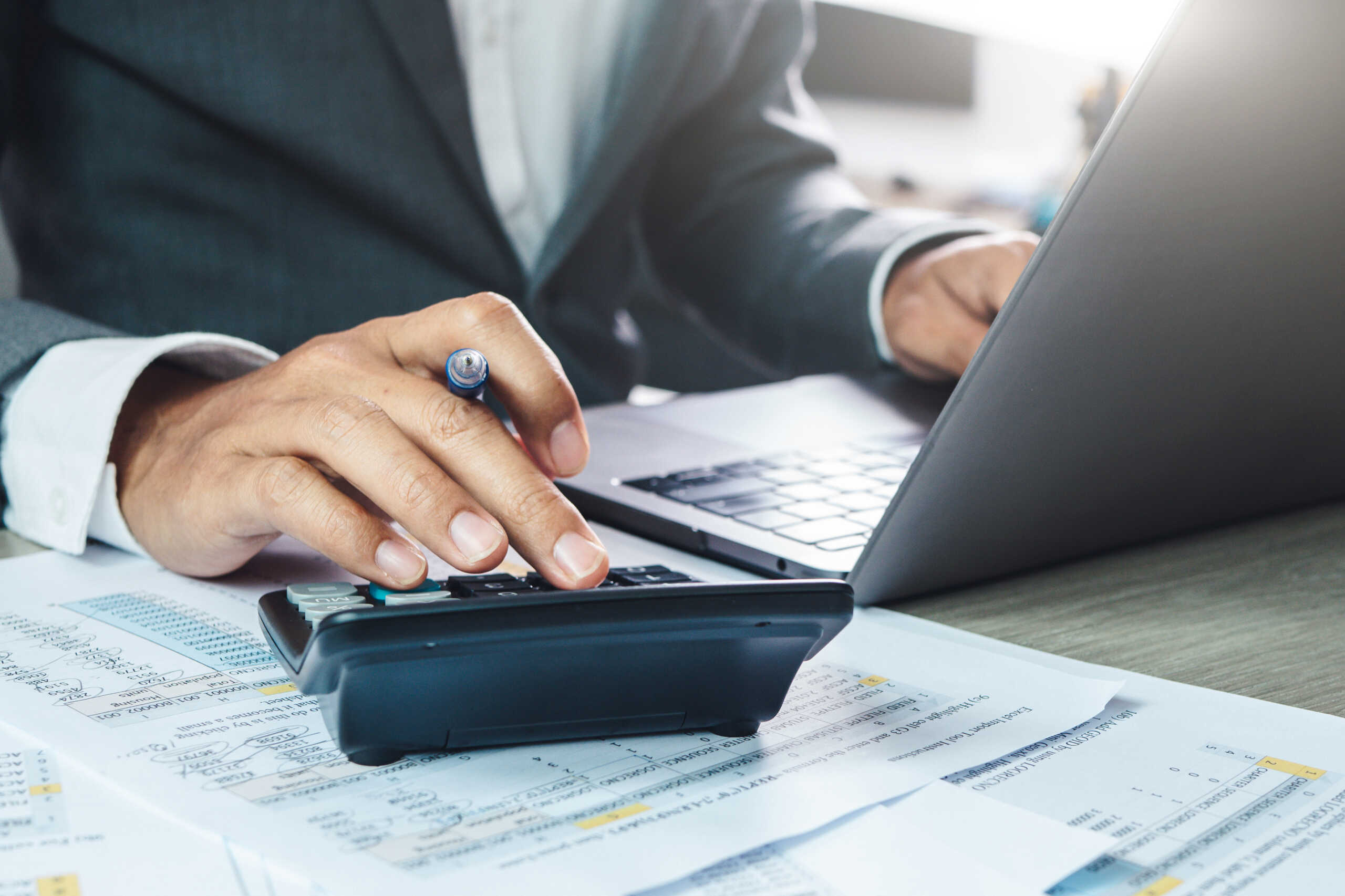 Hand man doing finances and calculate on desk about cost at home office