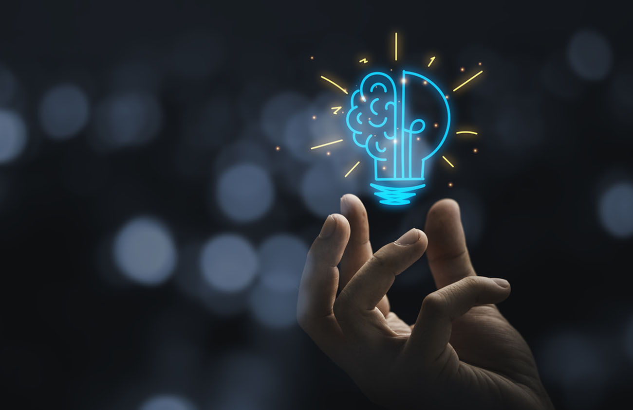 Hand holding drawing virtual lightbulb with brain on bokeh background for creative and smart thinking idea concep