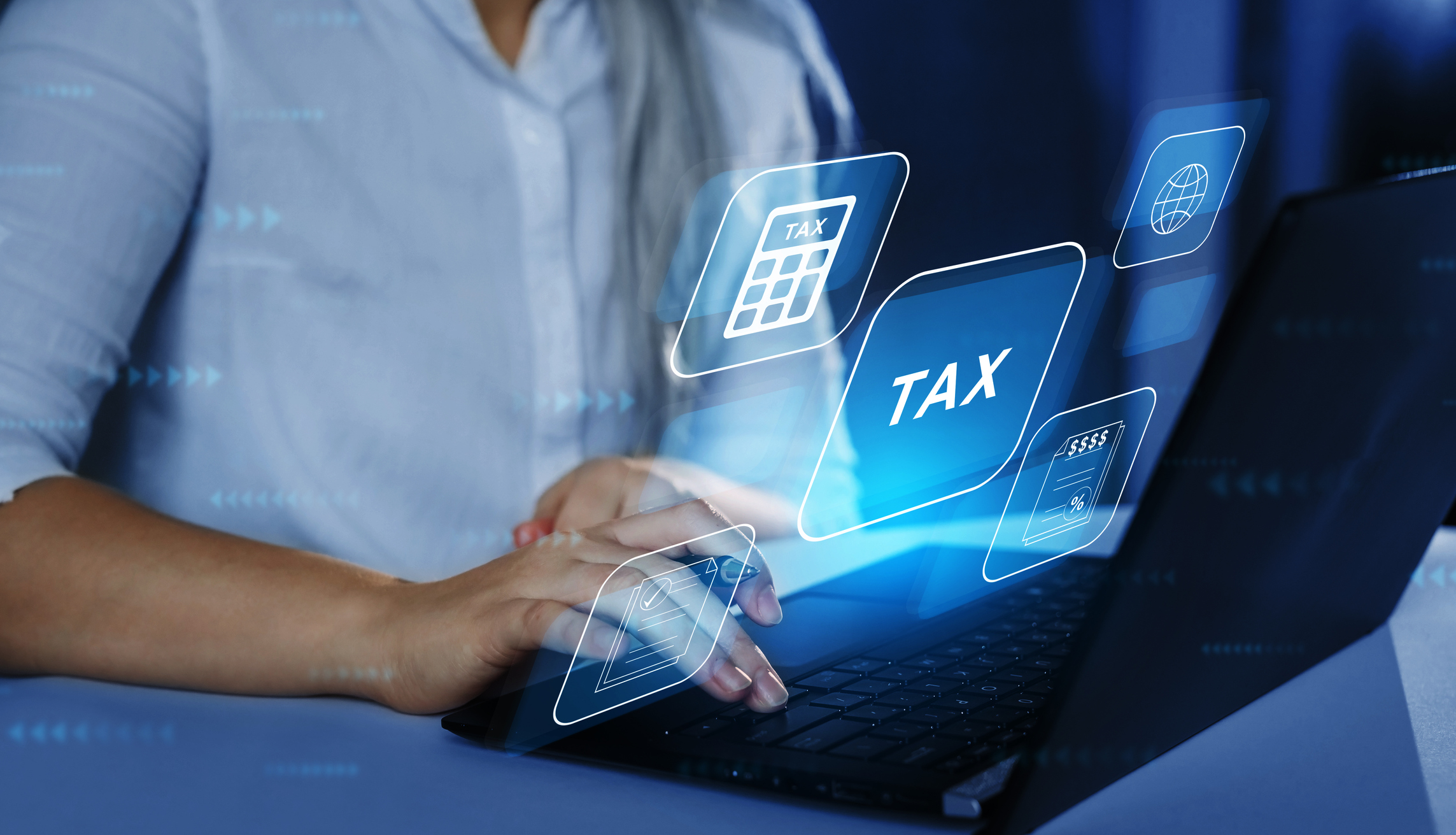 Business Woman using a laptop with digital graphic screen to complete income tax form online. Financial research,government taxes and calculation tax return concept. Tax Time.