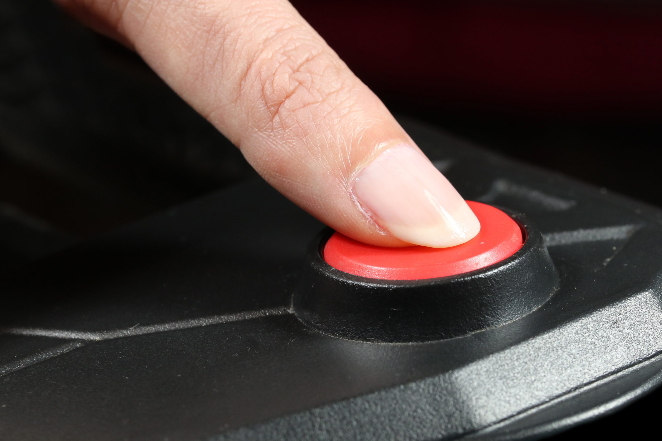 Pressing STOP or START button. Finger presses the red button.