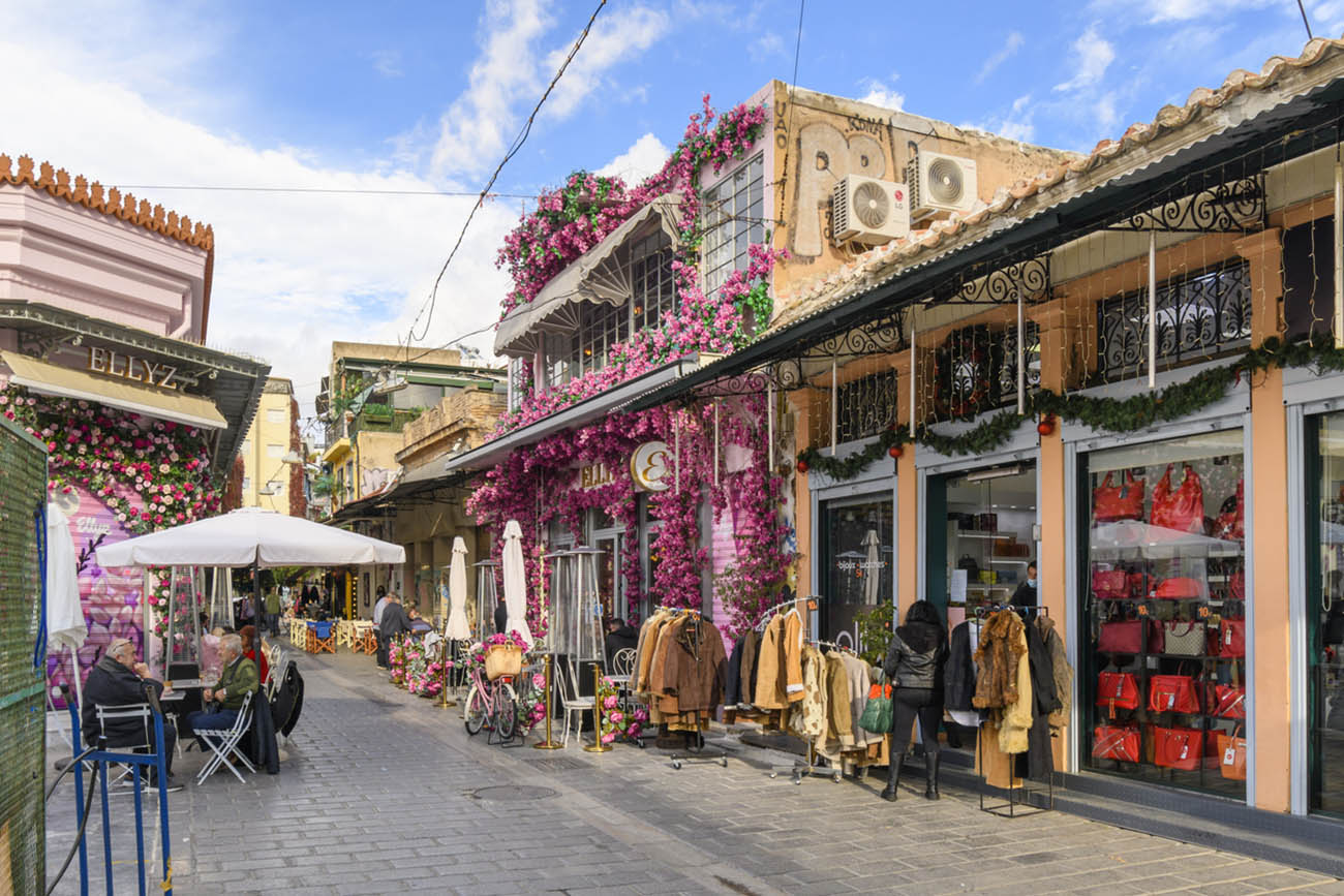 A colorful Ellyz cafe covered with pink and purple flowers, cafes and shops in the Monastiraki flea market district of Athens, Greece.