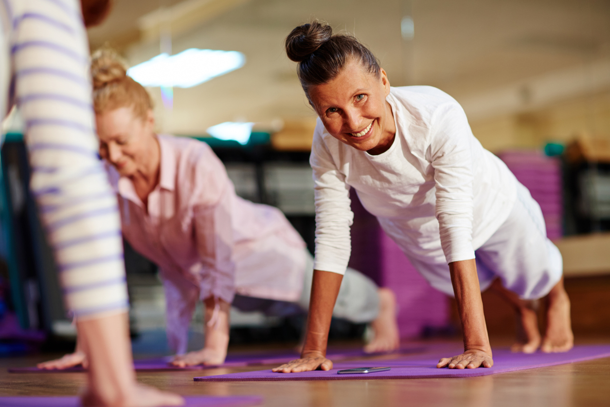 Happy woman doing push-ups on mat