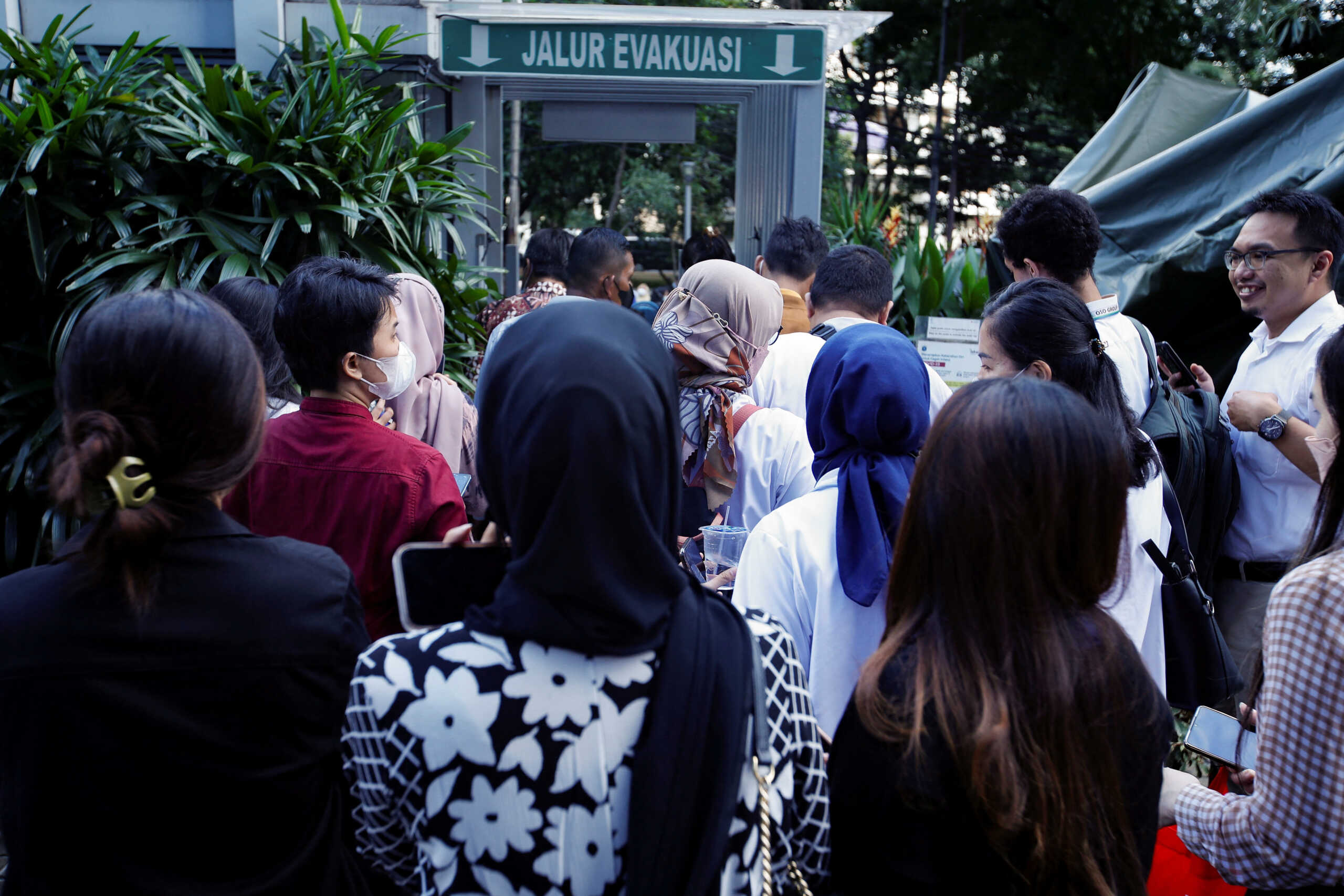 People gather as they are evacuated outside a building following an earthquake in Jakarta, Indonesia, November 21, 2022. REUTERS