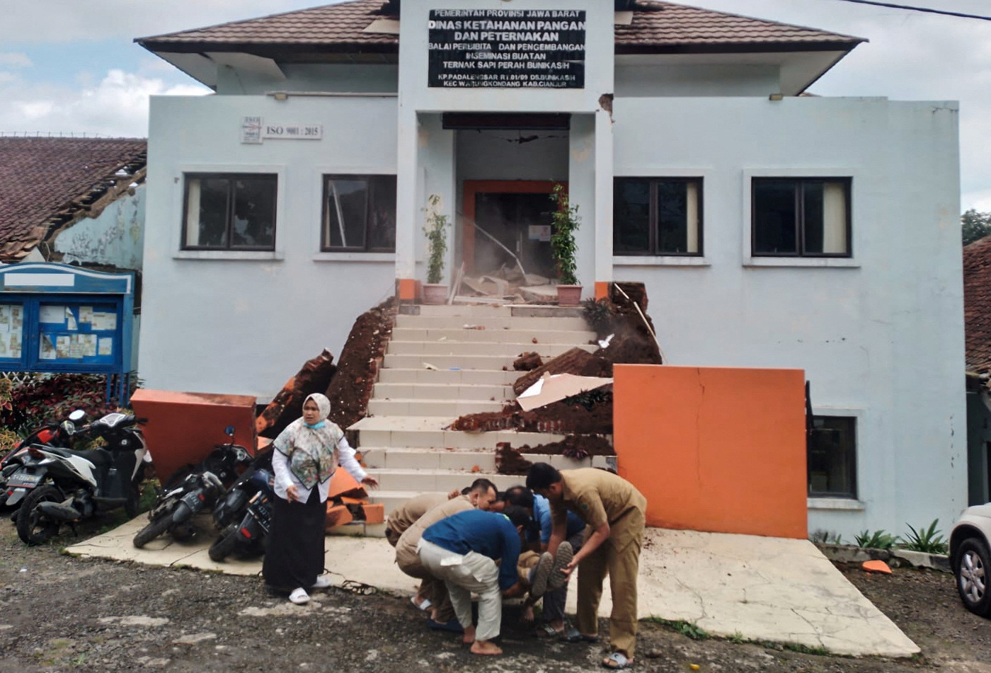 Municipality officers evacuate their injured colleague following an earthquake in Cianjur, West Java province, Indonesia, November 21, 2022. Antara Foto