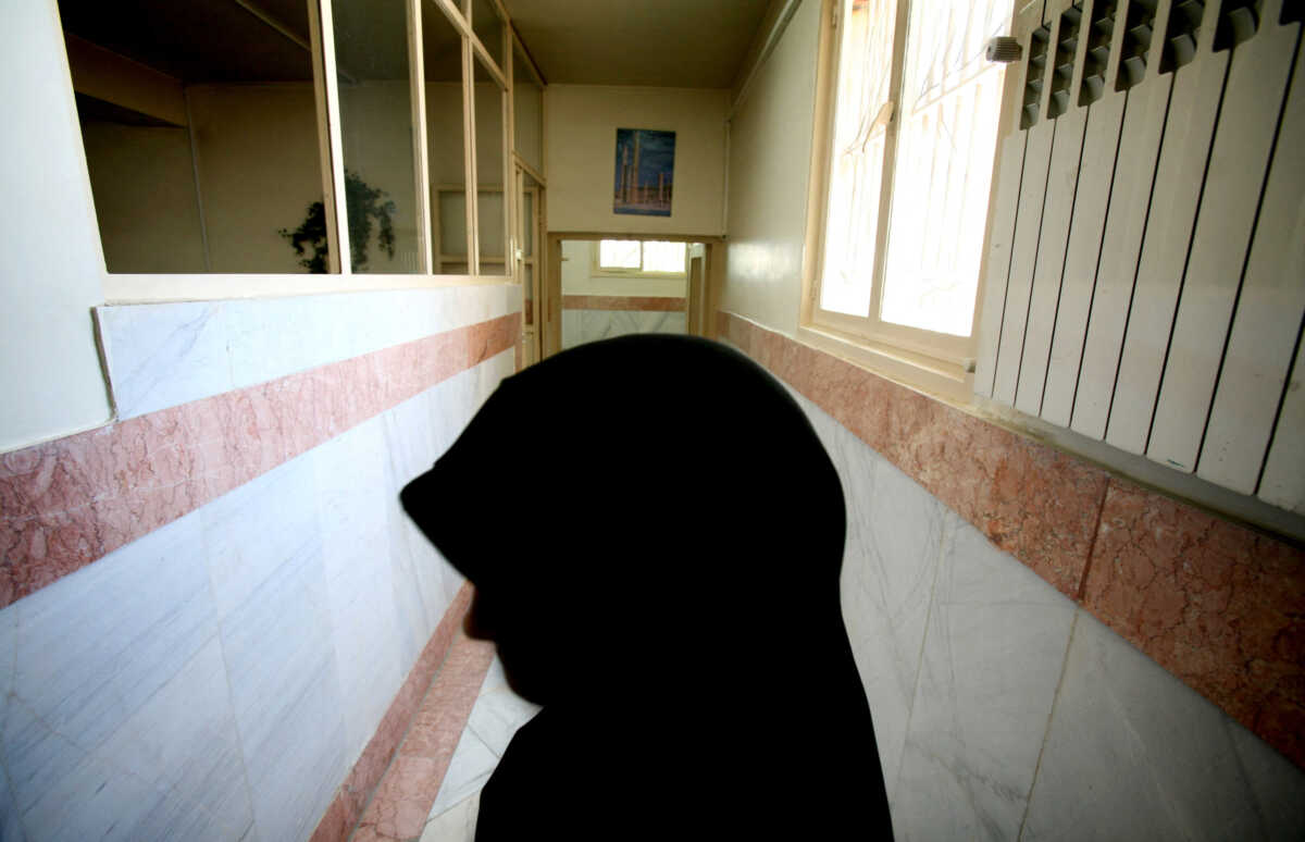 FILE PHOTO: A female prison guard stands along a corridor in Tehran's Evin prison June 13, 2006. Iranian police detained 70 people at a demonstration in favour of women's rights, the judiciary said on Tuesday, adding it was ready to review reports that the police had beaten some demonstrators.