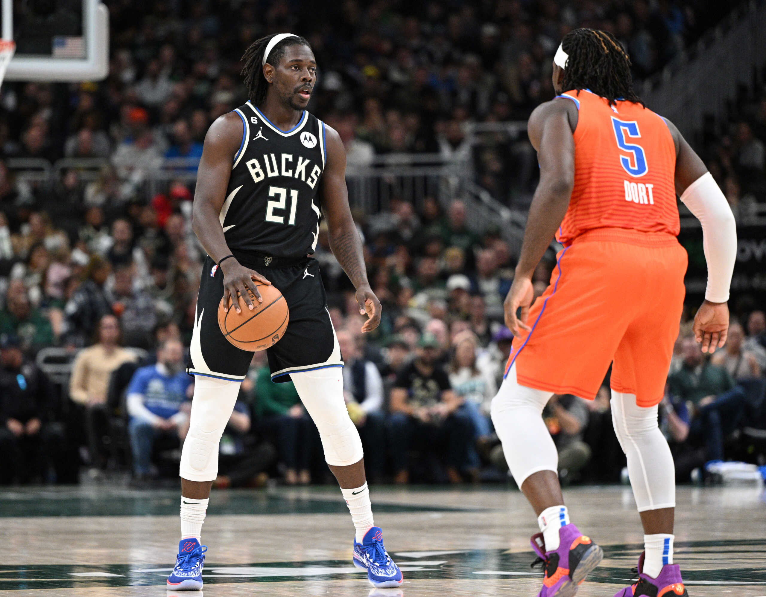 Nov 5, 2022; Milwaukee, Wisconsin, USA; Milwaukee Bucks guard Jrue Holiday (21) brings the ball up the court against Oklahoma City Thunder forward Luguentz Dort (5) in the second quarter at Fiserv Forum. Mandatory Credit: Michael McLoone-USA TODAY Sports