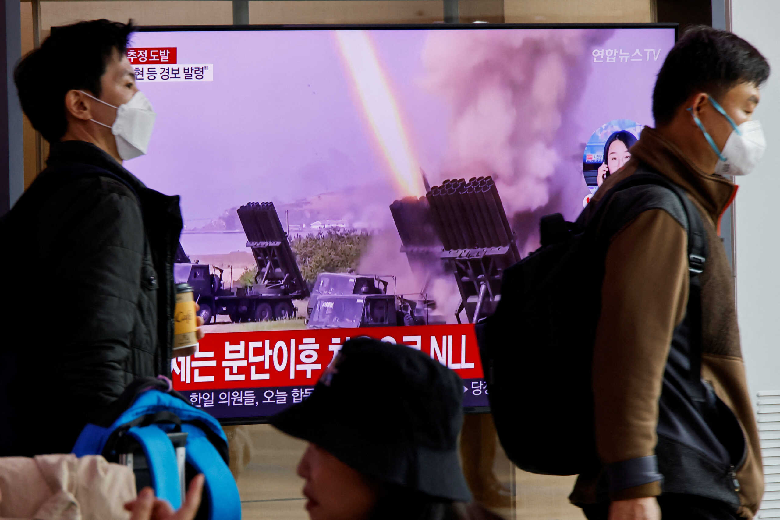 Men walk past a TV broadcasting a news report on North Korea firing a ballistic missile off its east coast, in Seoul, South Korea, November 3, 2022.  REUTERS