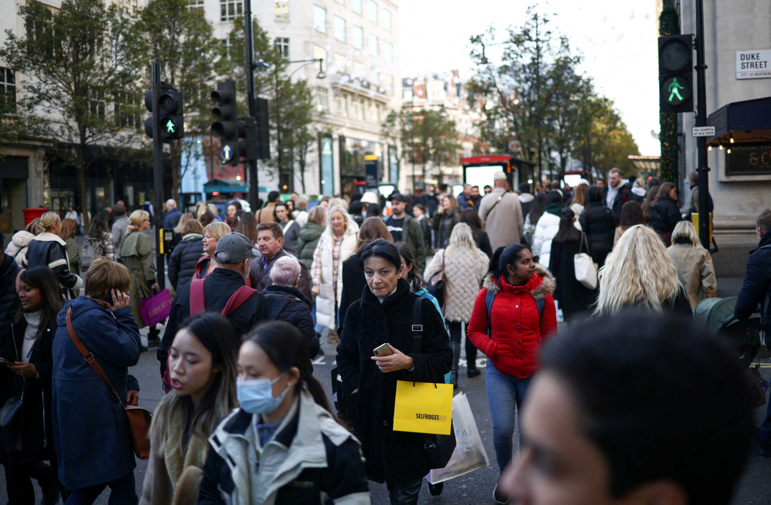 FILE PHOTO: People carry shopping bags during the Black Friday sales on Oxford Street in London, Britain, November 25, 2022. REUTERS