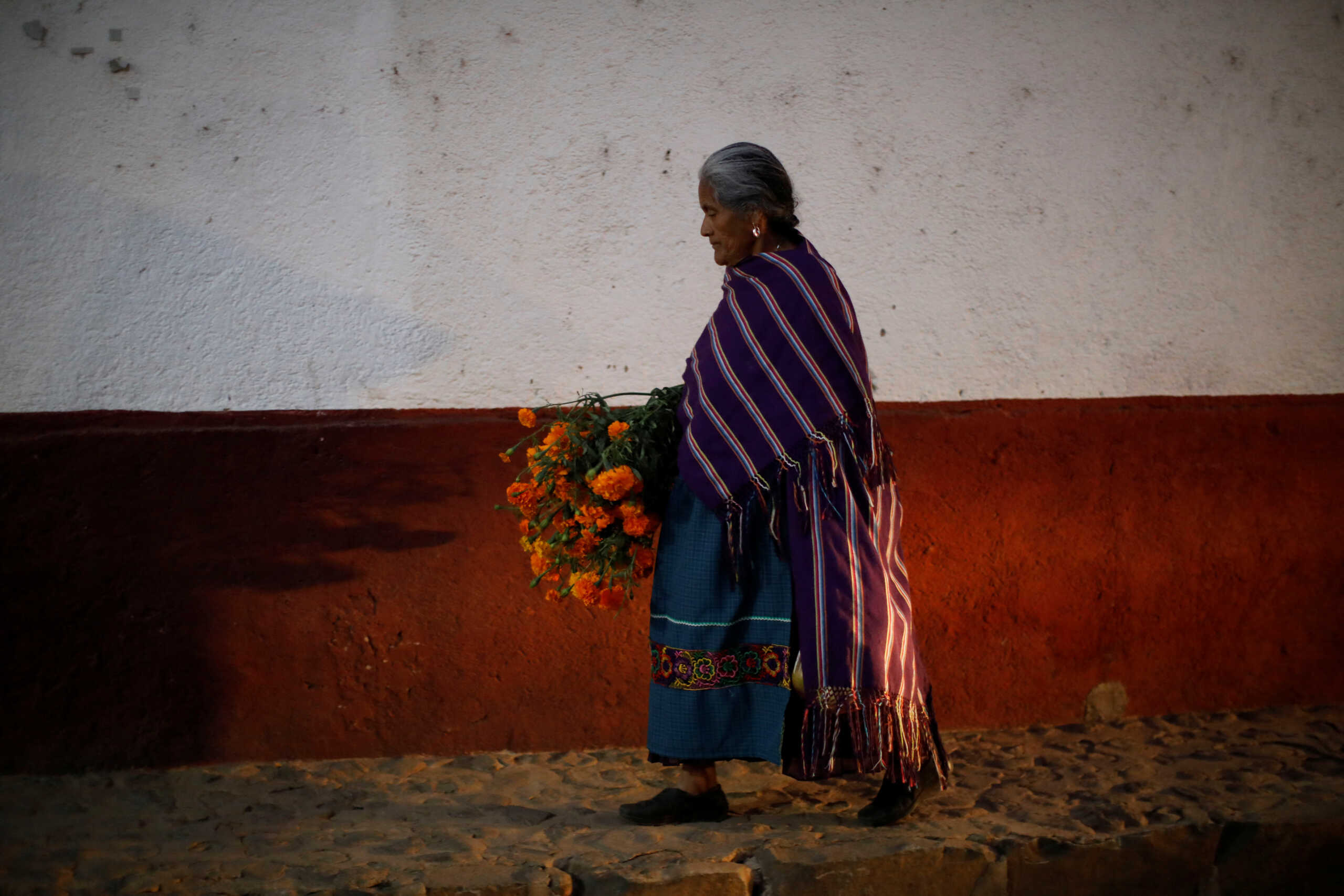 A women carries Cempasuchil Marigolds during the annual Day of the Dead celebration in Santa Fe de La Laguna, Michoacan state, Mexico November 1, 2022. REUTERS