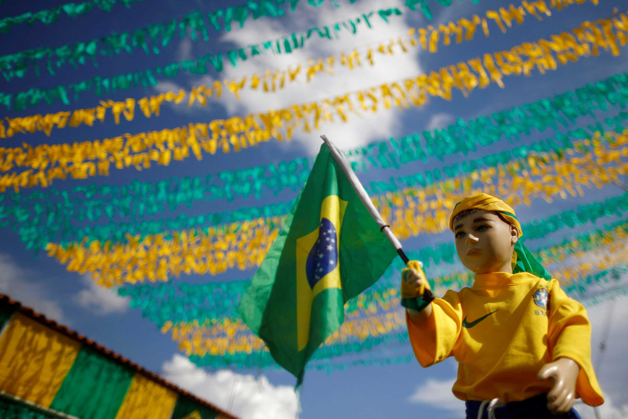 A doll dressed in the uniform of the Brazilian national soccer team stands on the street with decorations ahead of the upcoming 2022 FIFA World Cup Qatar in the Ceilandia neighbourhood of Brasilia, Brazil November 17, 2022. REUTERS