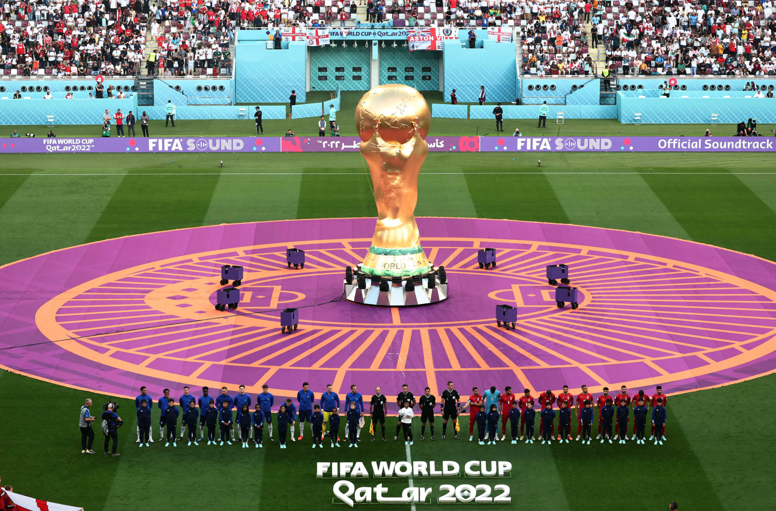 Soccer Football - FIFA World Cup Qatar 2022 - Group B - England v Iran - Khalifa International Stadium, Doha, Qatar - November 21, 2022 General view as a giant replica trophy is seen as the England and Iran players line up during the national anthems before the match REUTERS