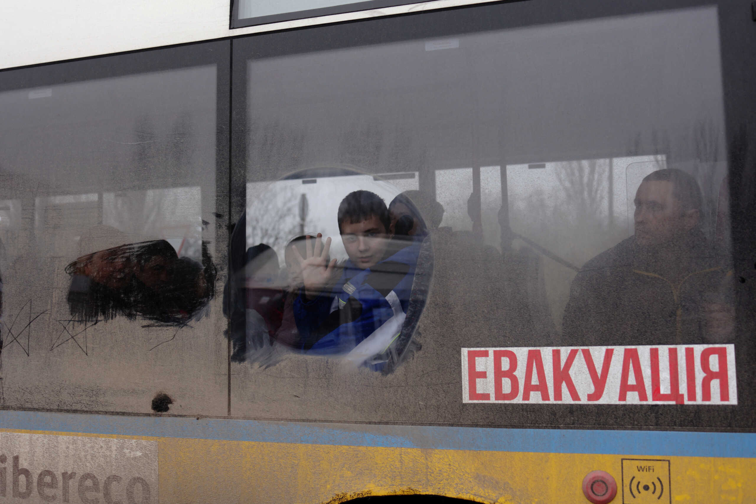 A boy waves as he leaves on an evacuation bus, after Russia's military retreat from Kherson, at the central bus station in Kherson, Ukraine November 24, 2022. REUTERS