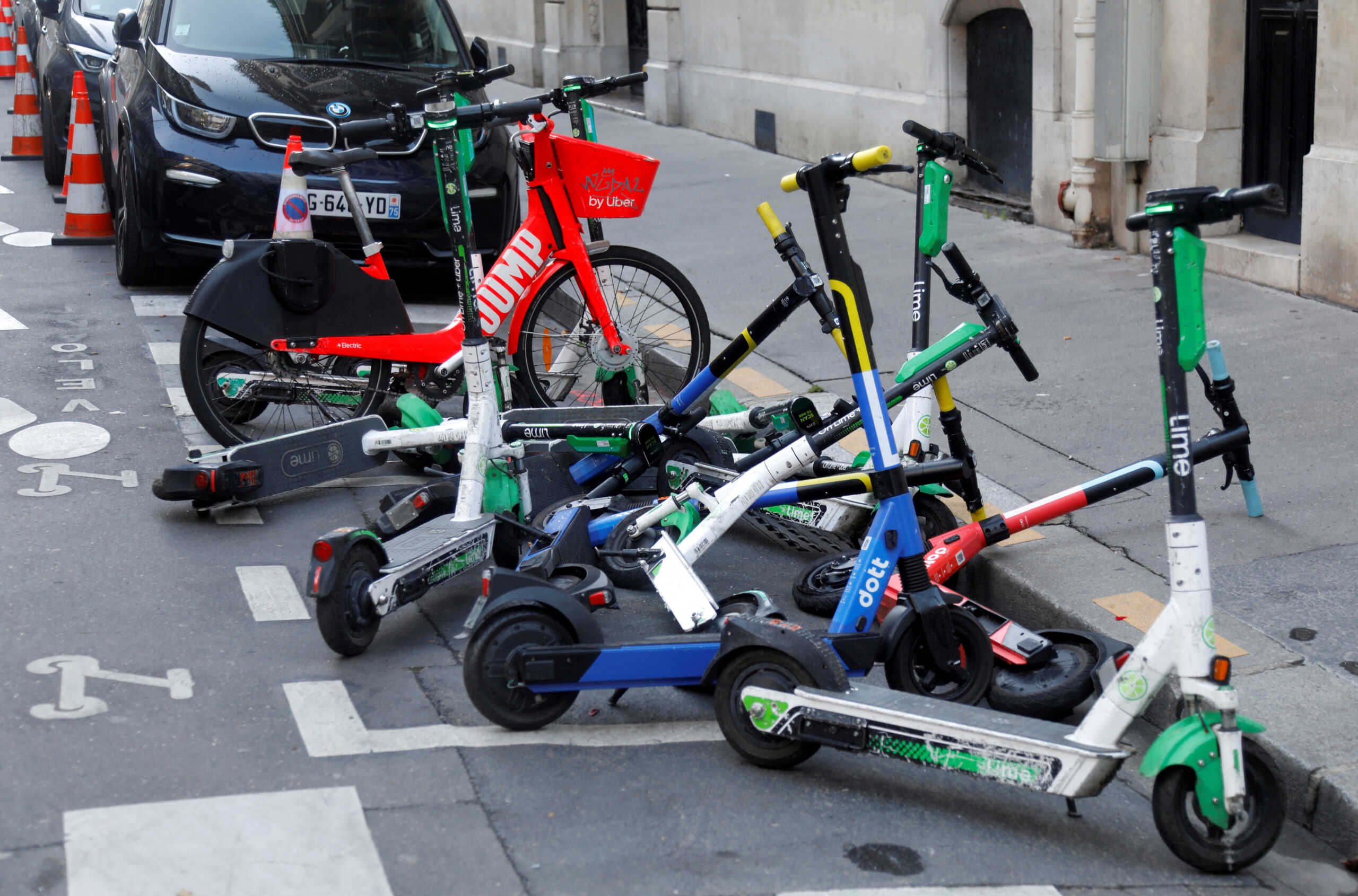 FILE PHOTO: Dock-free electric scooters by Lime and Dott sharing services are parked for rent in a street in Paris, France, December 1, 2020.  REUTERS
