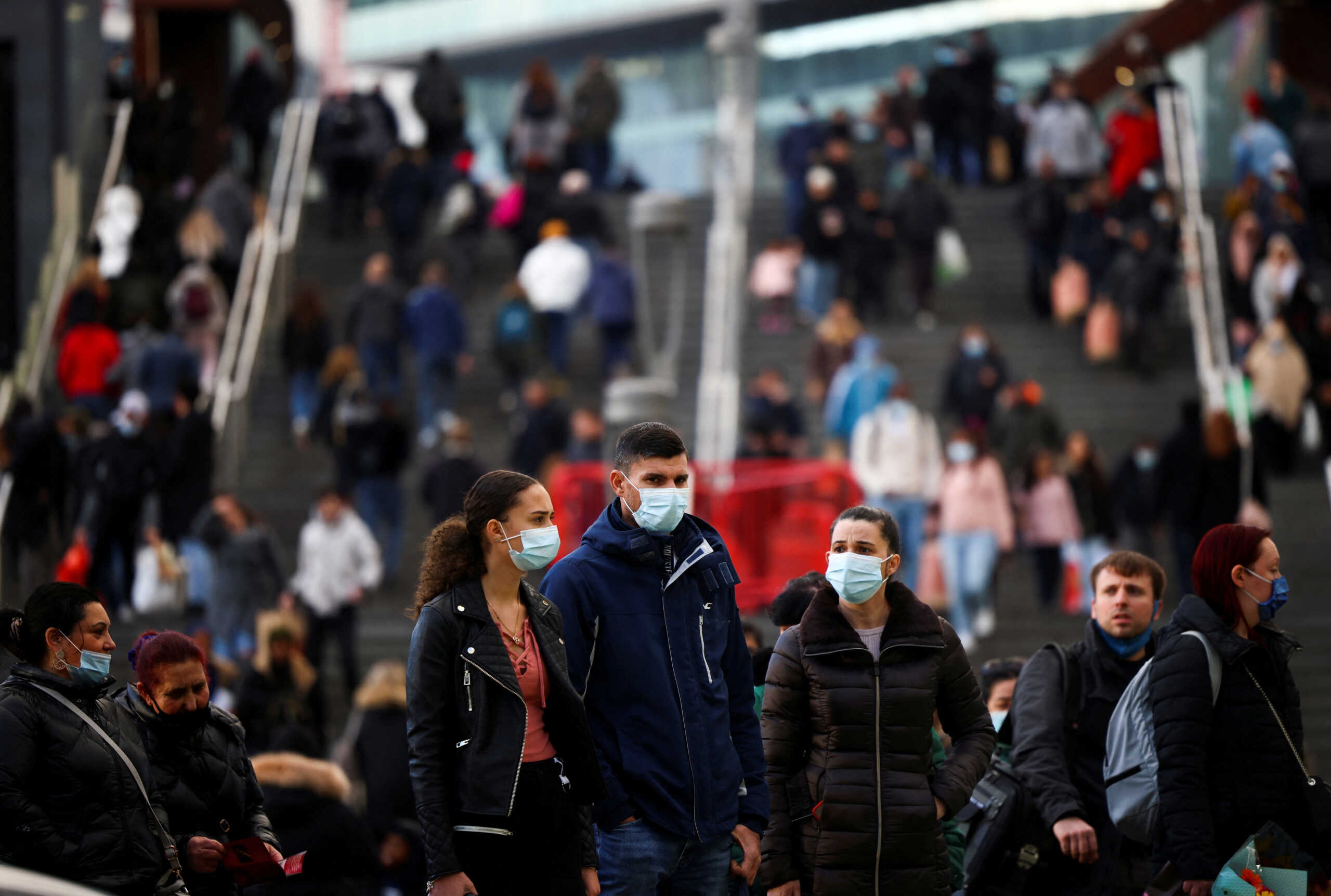 FILE PHOTO: People wearing protective face masks stand outside the Westfield Stratford City shopping centre, amid the coronavirus disease (COVID-19) outbreak in London, Britain, December 5, 2020. REUTERS