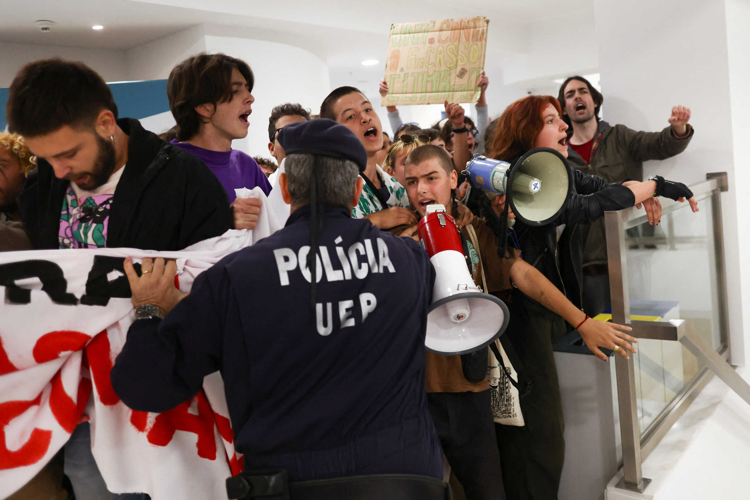 Police officers push protesters for climate change and against the use of fossil fuels after they entered a private event where, according to the local media, Portugal's Economy and Sea Minister Antonio Costa e Silva was participating in Lisbon, Portugal, November 12, 2022. REUTERS
