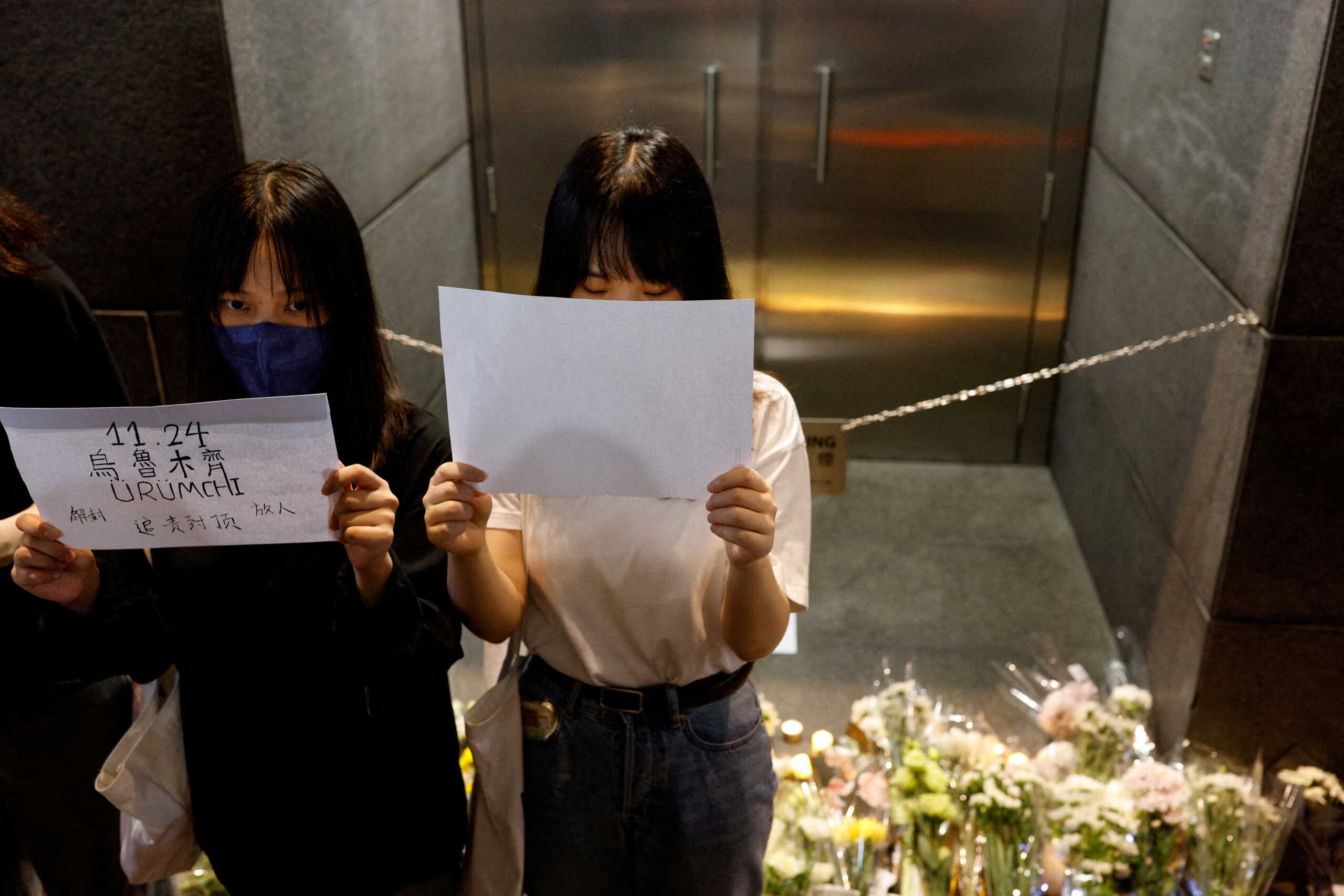 People hold sheets of paper in protest over coronavirus disease (COVID-19) restrictions in mainland China, during a commemoration of the victims of a fire in Urumqi, in Hong Kong, China November 28, 2022. REUTERS