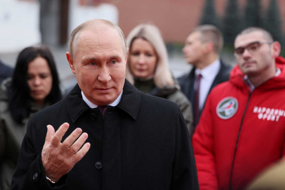 Russian President Vladimir Putin speaks with members of public associations, youth and volunteer organizations during a flower-laying ceremony at the monument to Kuzma Minin and Dmitry Pozharsky while marking Russia's Day of National Unity in Red Square in central Moscow, Russia November 4, 2022. Sputnik