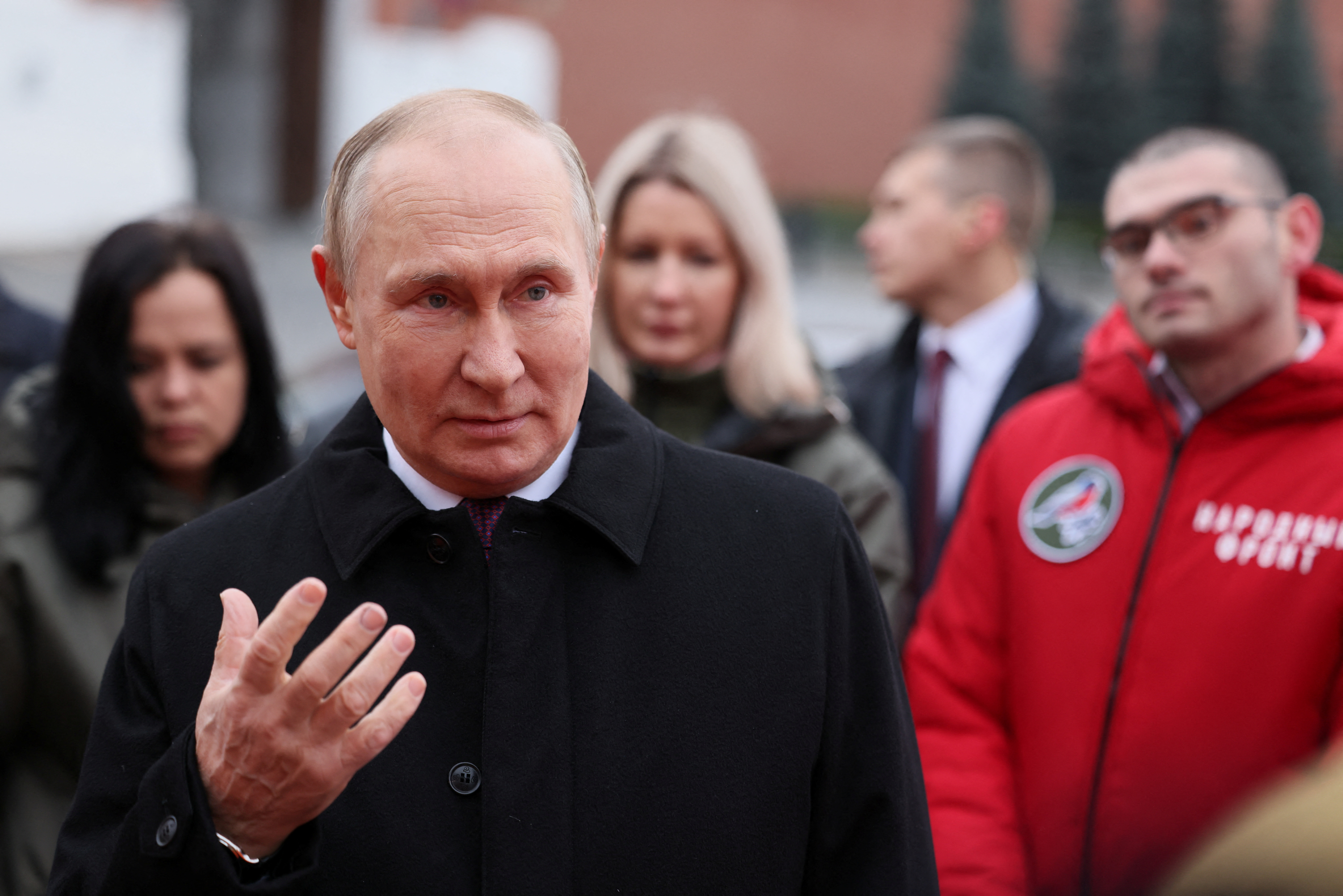 Russian President Vladimir Putin speaks with members of public associations, youth and volunteer organizations during a flower-laying ceremony at the monument to Kuzma Minin and Dmitry Pozharsky while marking Russia's Day of National Unity in Red Square in central Moscow, Russia November 4, 2022. Sputnik