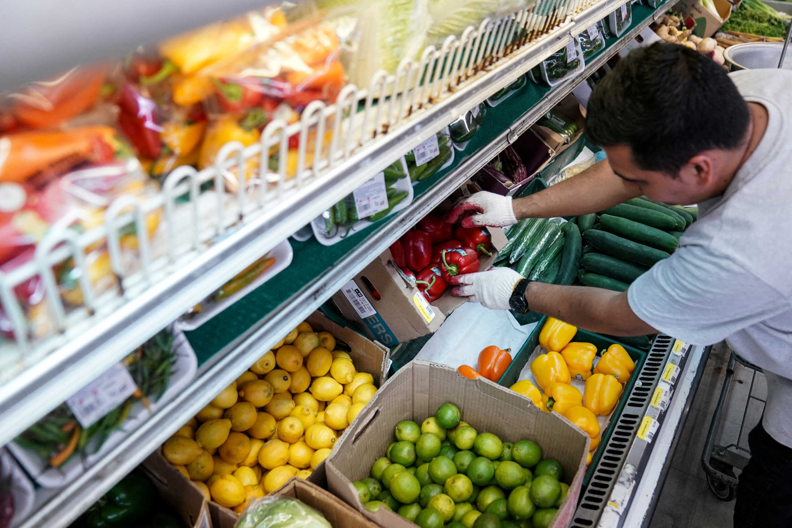 FILE PHOTO: A man arranges produce at Best World Supermarket in the Mount Pleasant neighborhood of Washington, D.C., U.S., August 19, 2022. REUTERS