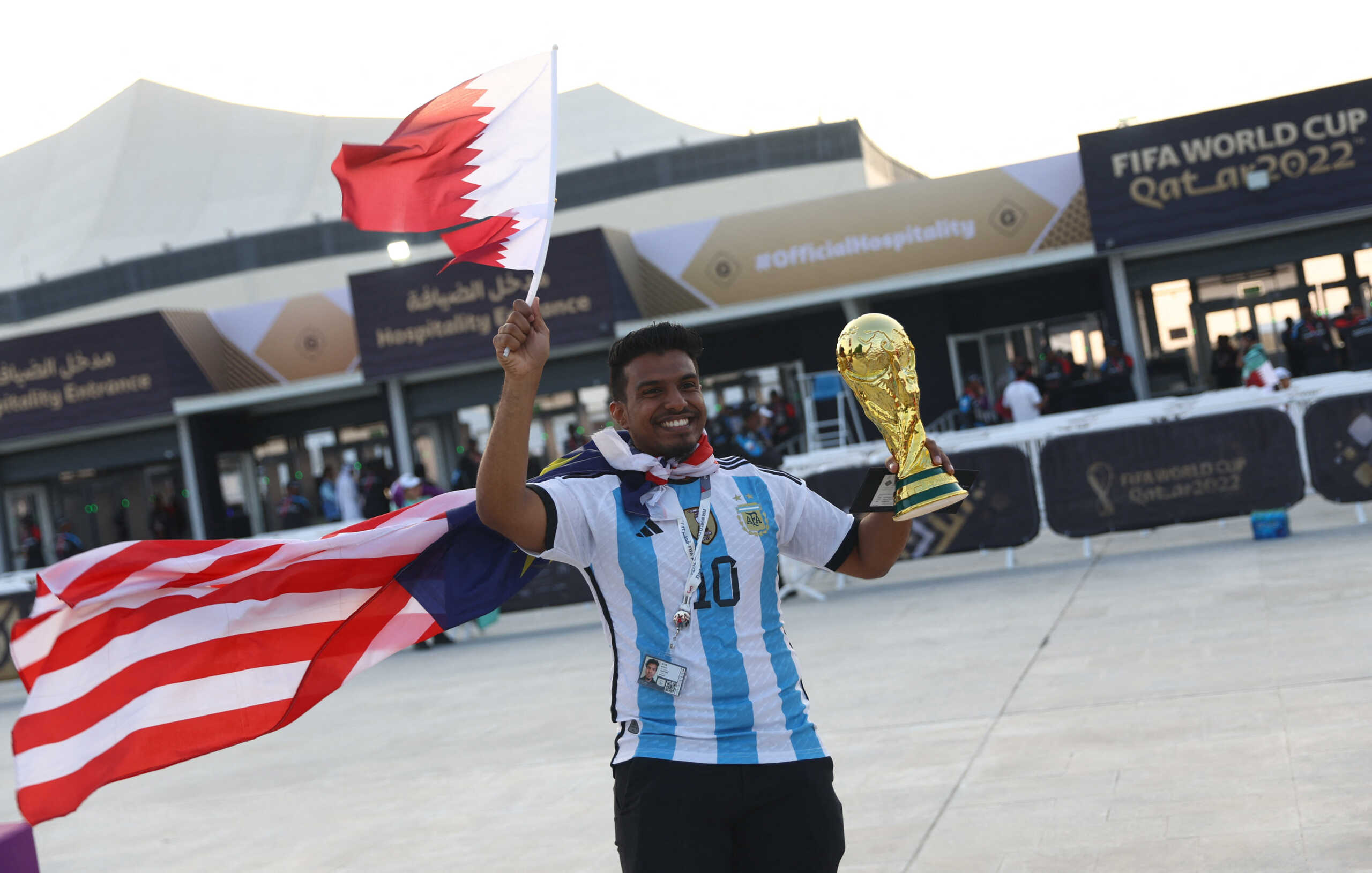 Soccer Football - FIFA World Cup Qatar 2022 - Group A - Qatar v Ecuador - Al Bayt Stadium, Al Khor, Qatar - November 20, 2022 A fan poses with a replica of the world cup outside the stadium before the match REUTERS