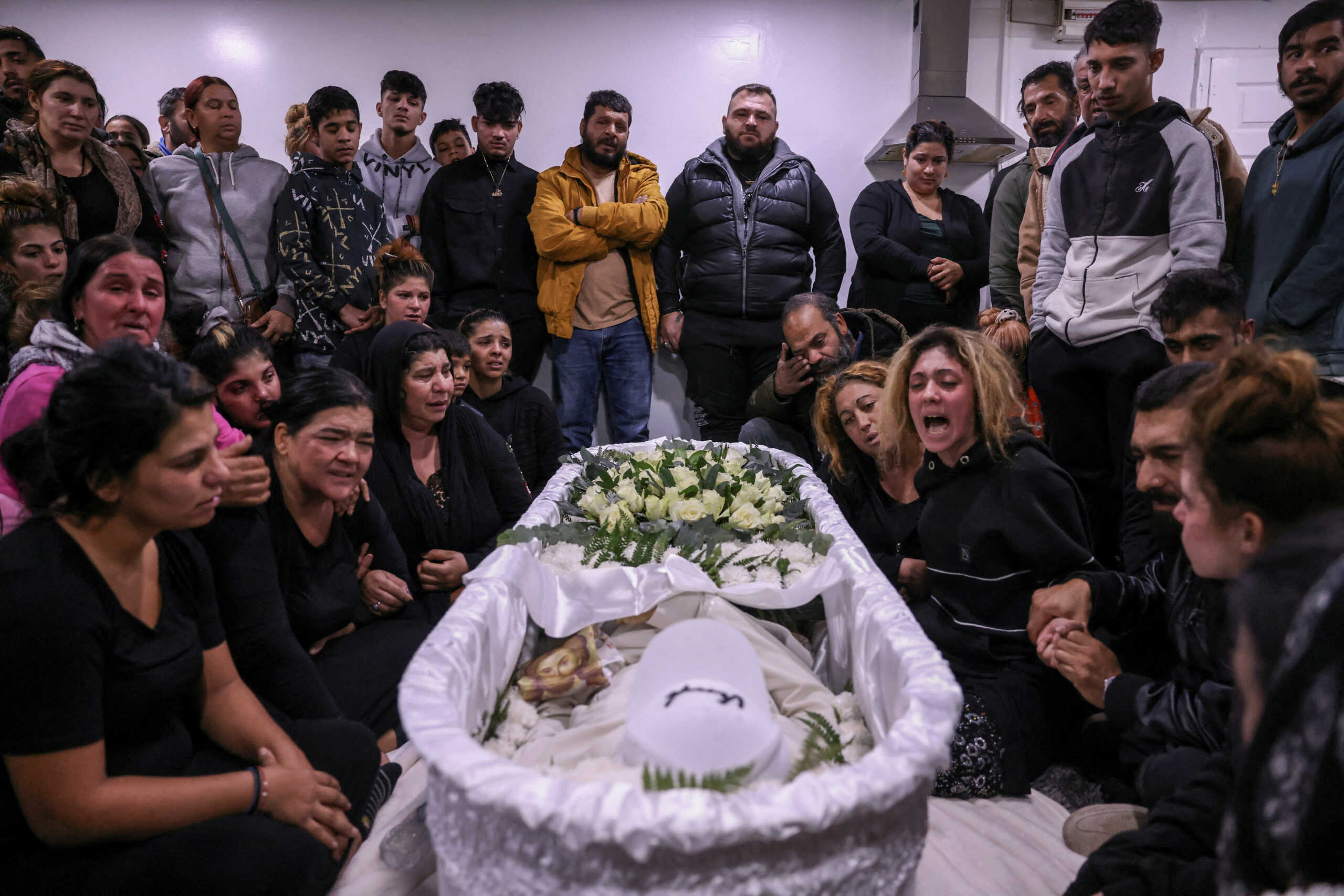 Relatives and friends of 16-year old Roma Costas Fragoulis, who was fatally shot by police, mourn next to his coffin in his house, in Thessaloniki, Greece, December 14, 2022. REUTERS