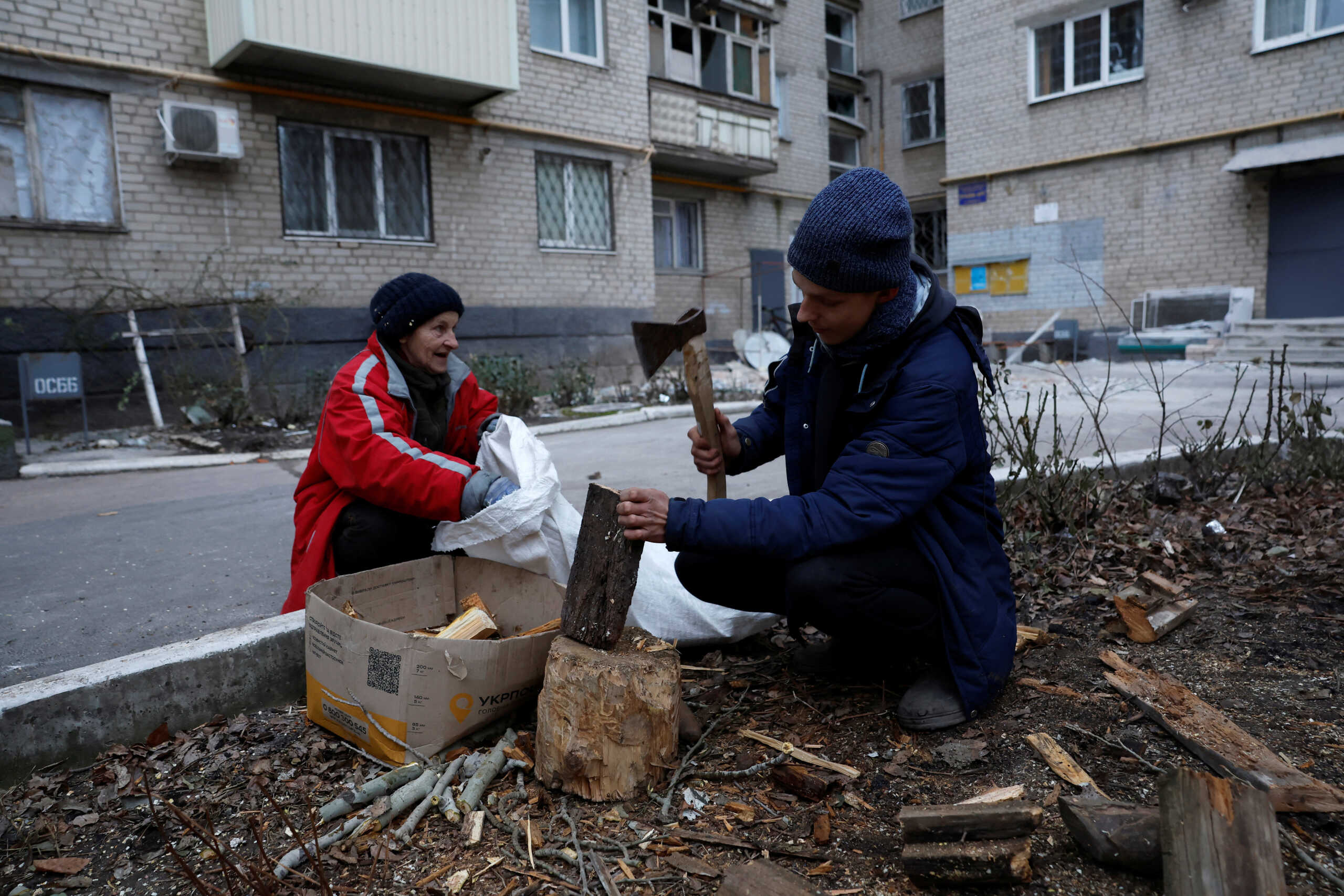 A man chops wood from a tree that fell down from a strike, to burn for heat, as Russia's attack on Ukraine continues, during intense shelling in Bakhmut, Ukraine, December 26, 2022. REUTERS