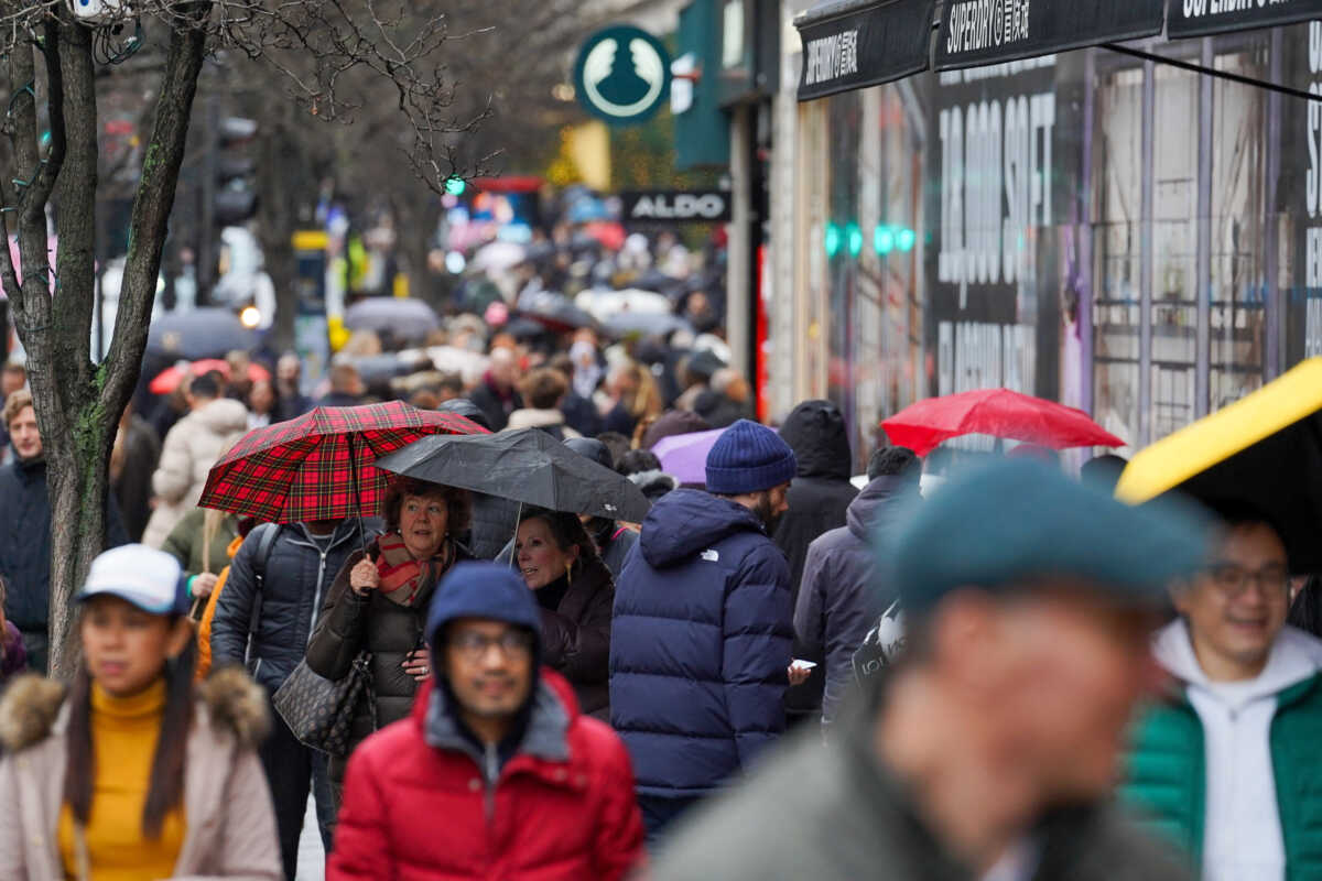 People walk past sale signage on Oxford Street during the third day of Boxing Day sales, in London, Britain December 28, 2022. REUTERS