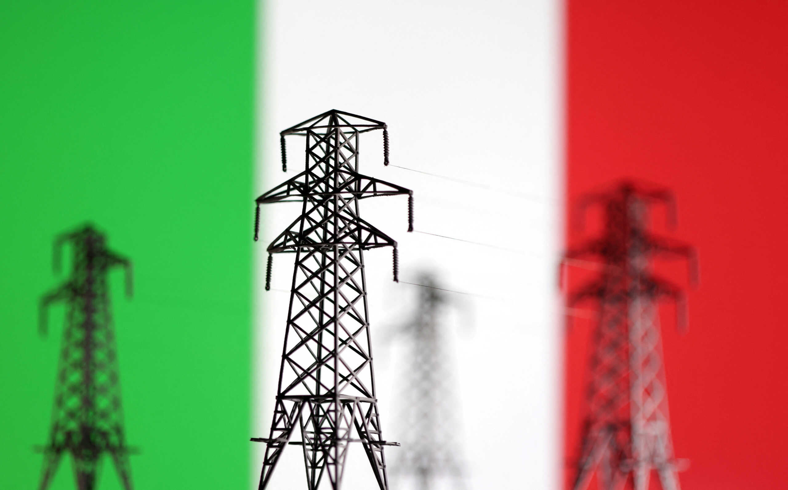 Electric power transmission miniatures are seen in front of displayed Italian flag in this illustration taken, December 5, 2022. REUTERS