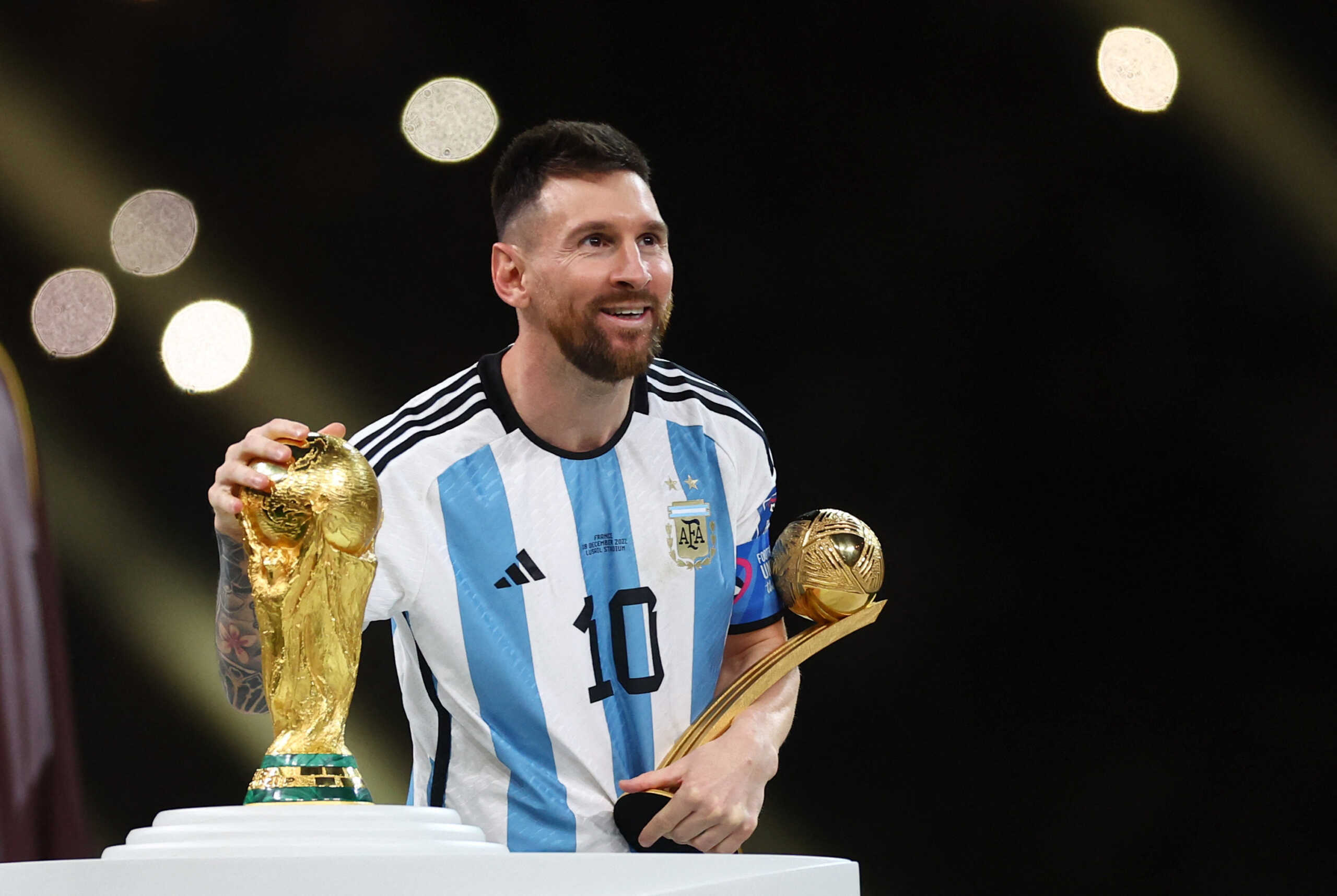 Soccer Football - FIFA World Cup Qatar 2022 - Final - Argentina v France - Lusail Stadium, Lusail, Qatar - December 18, 2022 Argentina's Lionel Messi touches the World Cup trophy after collecting the Golden Ball award REUTERS