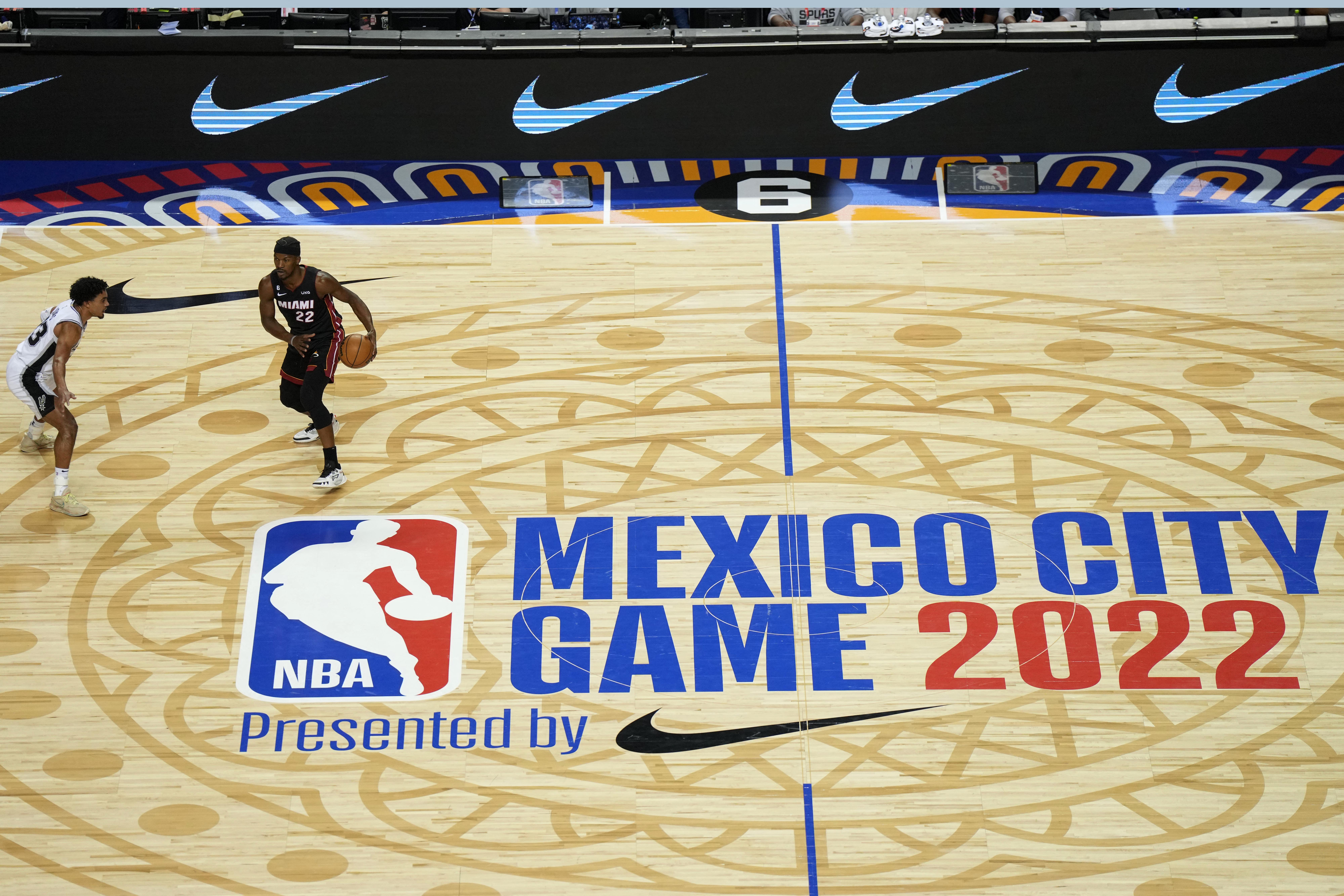 Dec 17, 2022; Mexico City, MEX; A general overall view of the NBA Mexico City Game 2022 logo at center court as Miami Heat forward Jimmy Butler (22) dribbles the ball against San Antonio Spurs guard Tre Jones (33) during the first half at the Arena de Ciudad de Mexico. Mandatory Credit: Kirby Lee-USA TODAY Sports