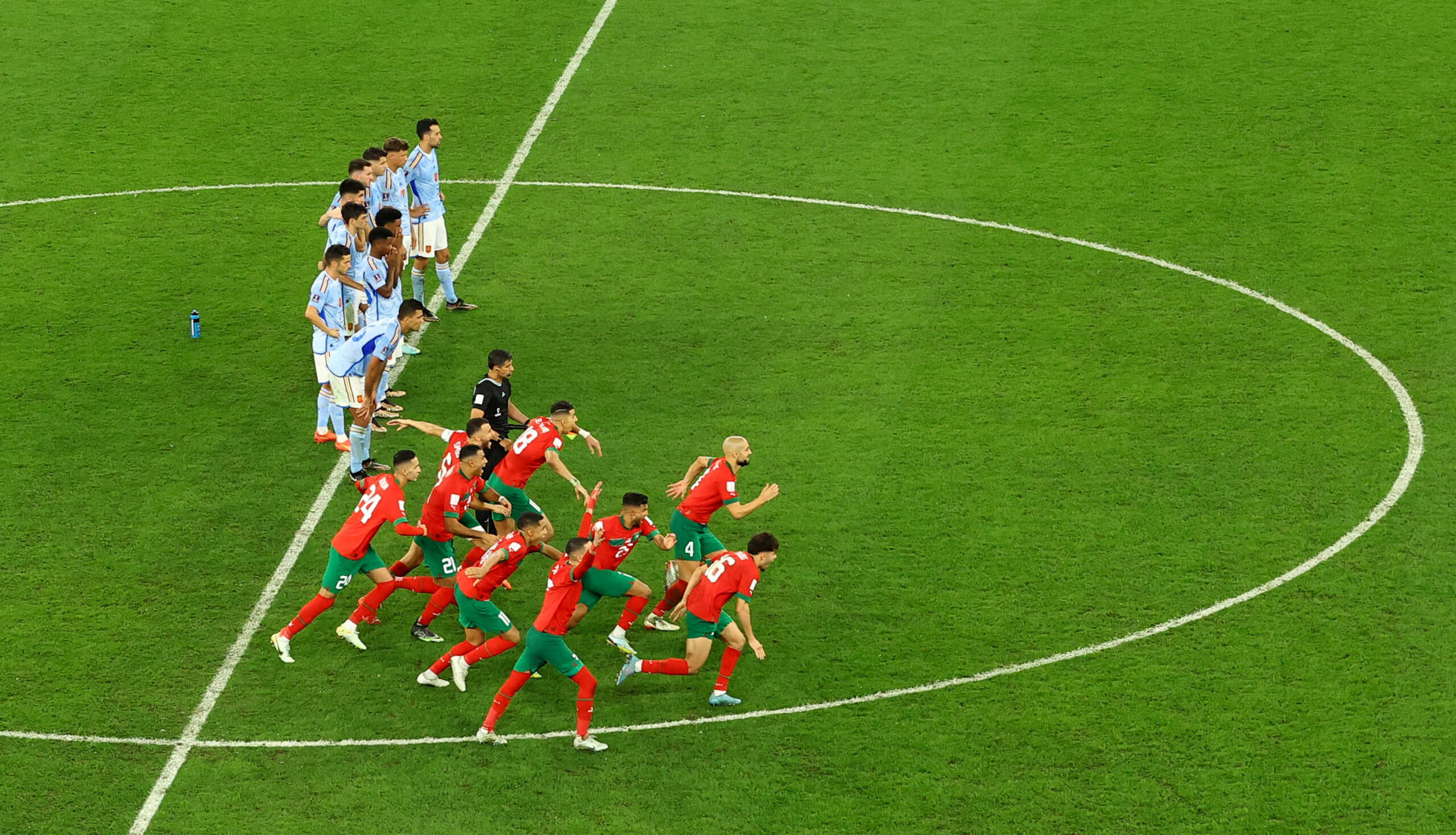 Soccer Football - FIFA World Cup Qatar 2022 - Round of 16 - Morocco v Spain - Education City Stadium, Al Rayyan, Qatar - December 6, 2022 Morocco players celebrate qualifying for the quarter finals as Spain players looks dejected REUTERS