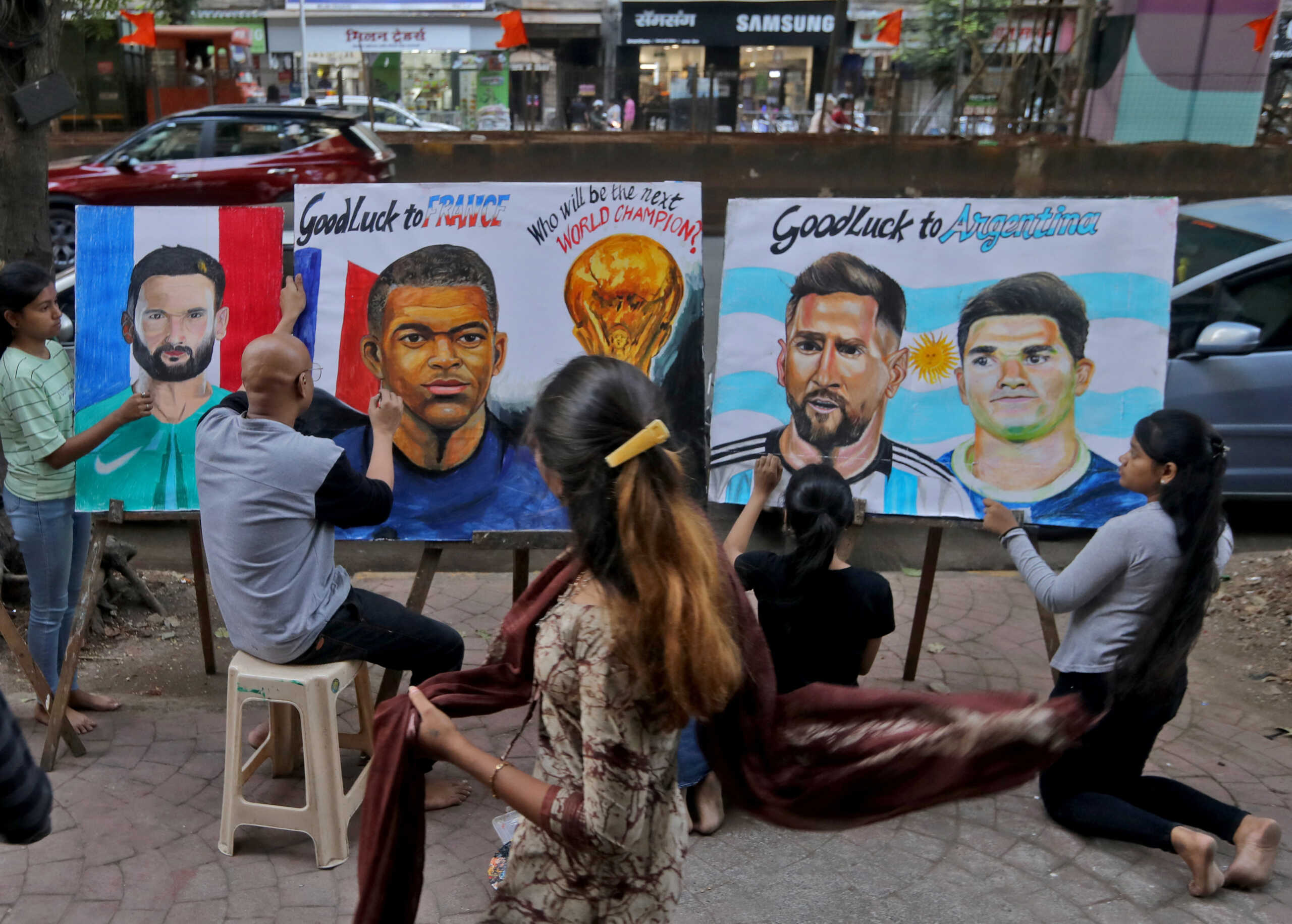 Students apply finishing touches to the portraits of soccer players Hugo Lloris, Kylian Mbappe, Messi and Julian Alvarez ahead of the Qatar 2022 Fifa World Cup Final between Argentina and France, outside an art school in Mumbai, India, December 16, 2022. REUTERS