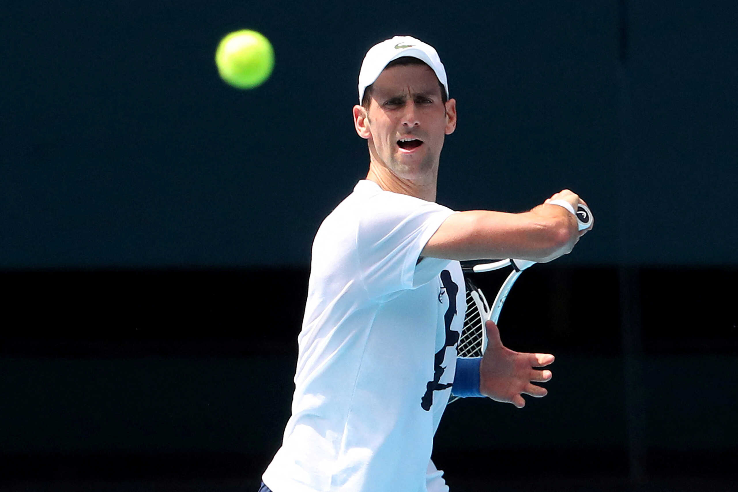 FILE PHOTO: Serbian tennis player Novak Djokovic practices on Rod Laver Arena ahead of the 2022 Australian Open at Melbourne Park, in Melbourne, Australia, January 11, 2022. Kelly Defina