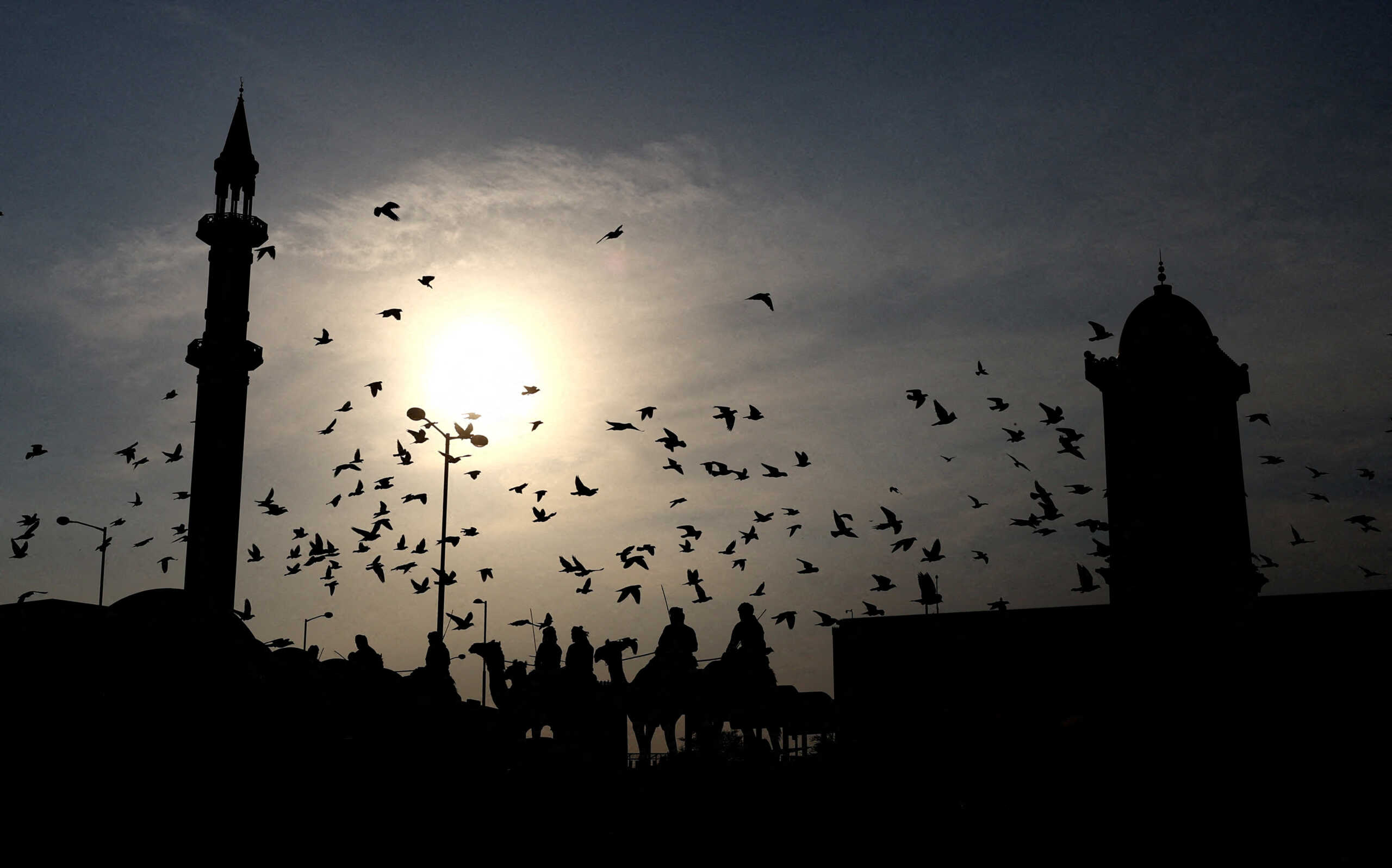 Soccer Football - FIFA World Cup Qatar 2022 - Doha, Qatar - November 30, 2022 People on camels are pictured outside kings parliament building in Qatar REUTERS