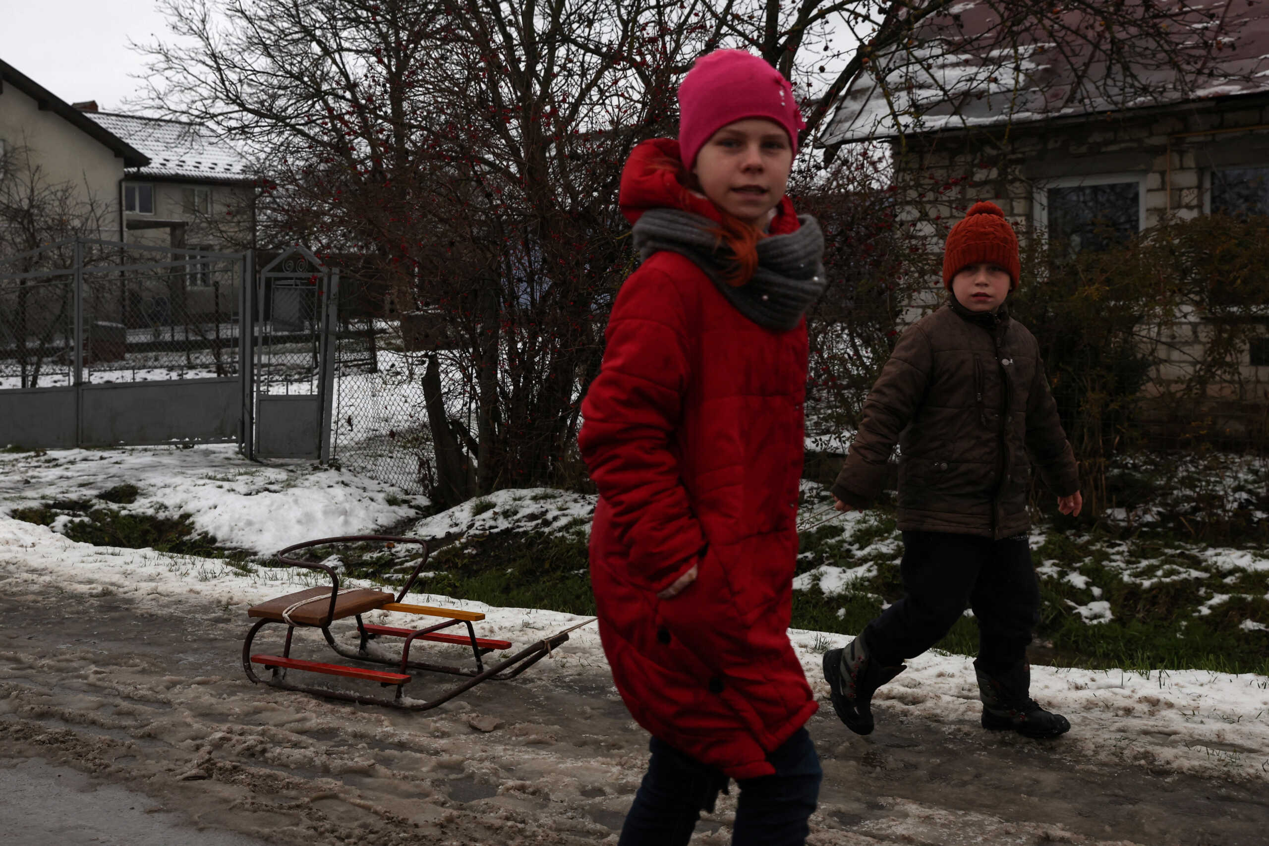 A child pulls a sled in the snow, as Russia's attack on Ukraine continues, in the village of Vynnychky outside of Lviv, Ukraine, December 16, 2022. REUTERS