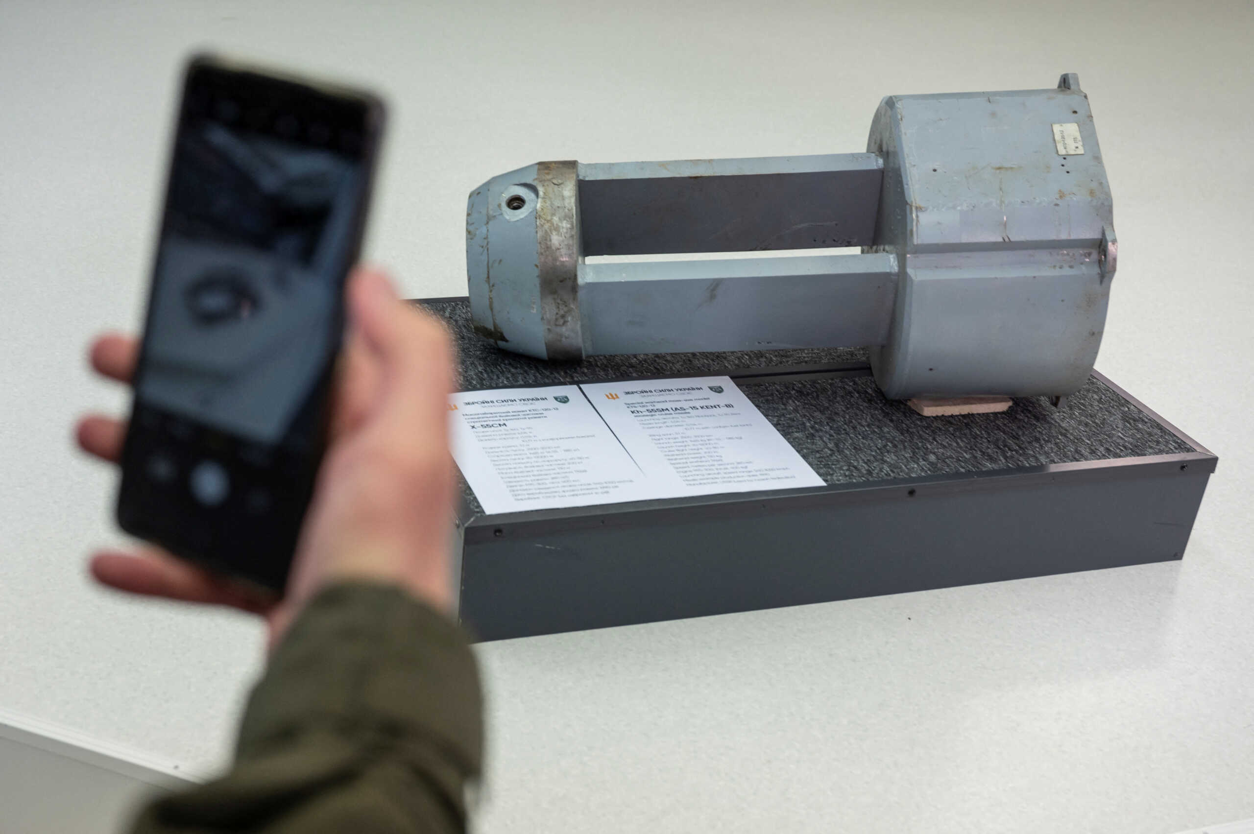 A member of the Ukrainian National Guard takes a picture of a dud warhead imitating a nuclear part of a Kh-55SM strategic cruise missile, which was used by Russian troops during a recent missile attack, during a news conference Kyiv, Ukraine December 1, 2022.  REUTERS