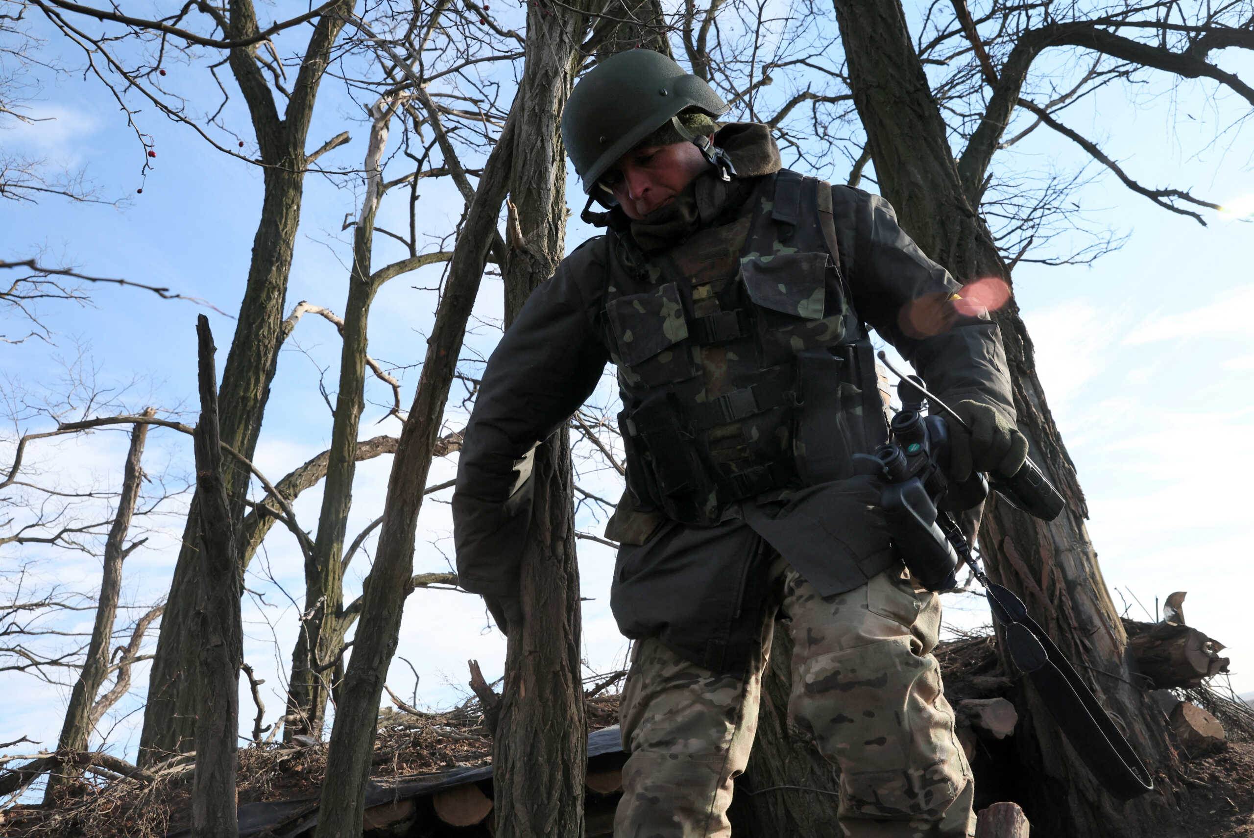 A member of the 68th Independent Jager Brigade of the Ukrainian Army climbs back into the trenches after scanning the horizon for Russian military from his position near the frontline in the Southern Donbas region in Ukraine, November 29, 2022. REUTERS