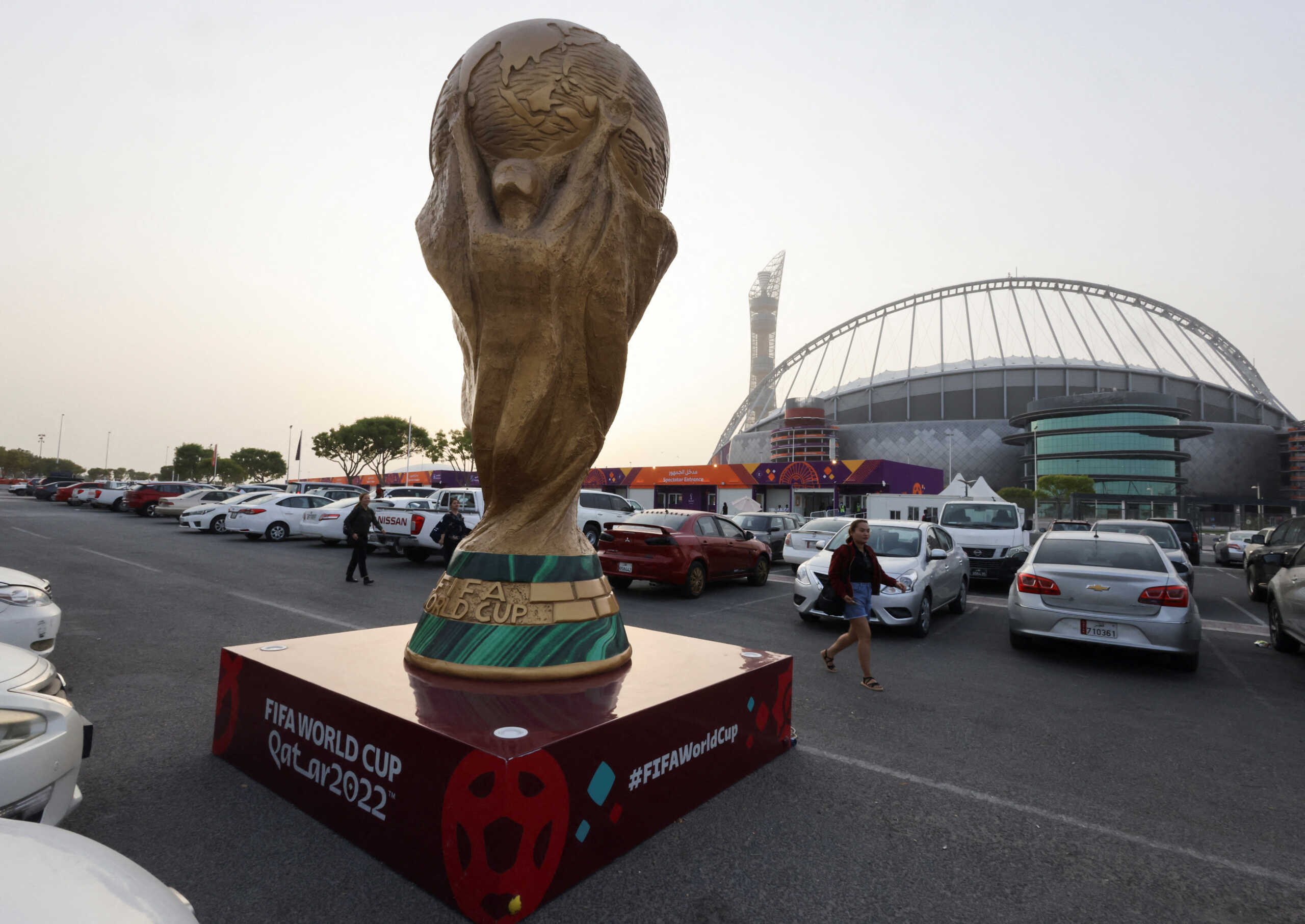 People walk next to a sculpture of the World Cup trophy in front of Khalifa International Stadium ahead of the FIFA 2022 World Cup soccer tournament in Doha, Qatar November 9, 2022. REUTERS