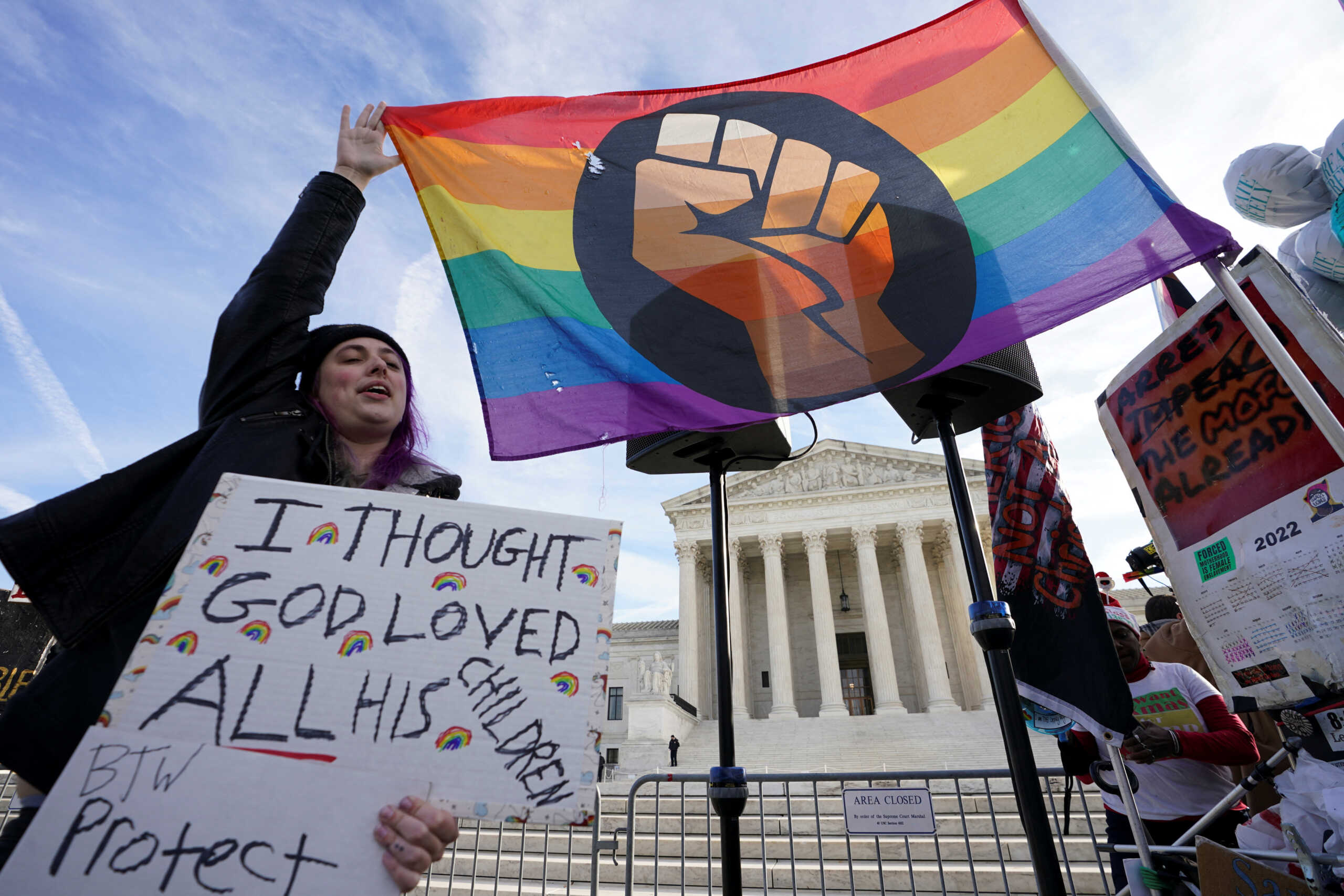 Protesters hold an LGBT rights rainbow (pride) flag as activists gather outside the U.S. Supreme Court, where justices were set to hear arguments in a major case pitting LGBT rights against a claim that the constitutional right to free speech exempts artists from anti-discrimination laws in a dispute involving an evangelical Christian web designer who refuses to provide her services for same-sex marriages, in Washington, U.S., December 5, 2022. REUTERS