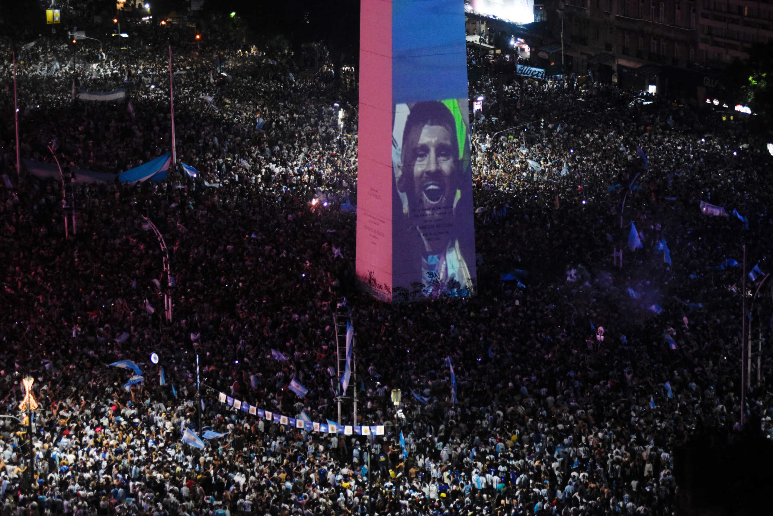 Soccer Football - FIFA World Cup Final Qatar 2022 - Fans in Buenos Aires - Buenos Aires, Argentina - December 18, 2022  Argentina fans celebrate winning the World Cup at the Obelisk with an image of Lionel Messi REUTERS
