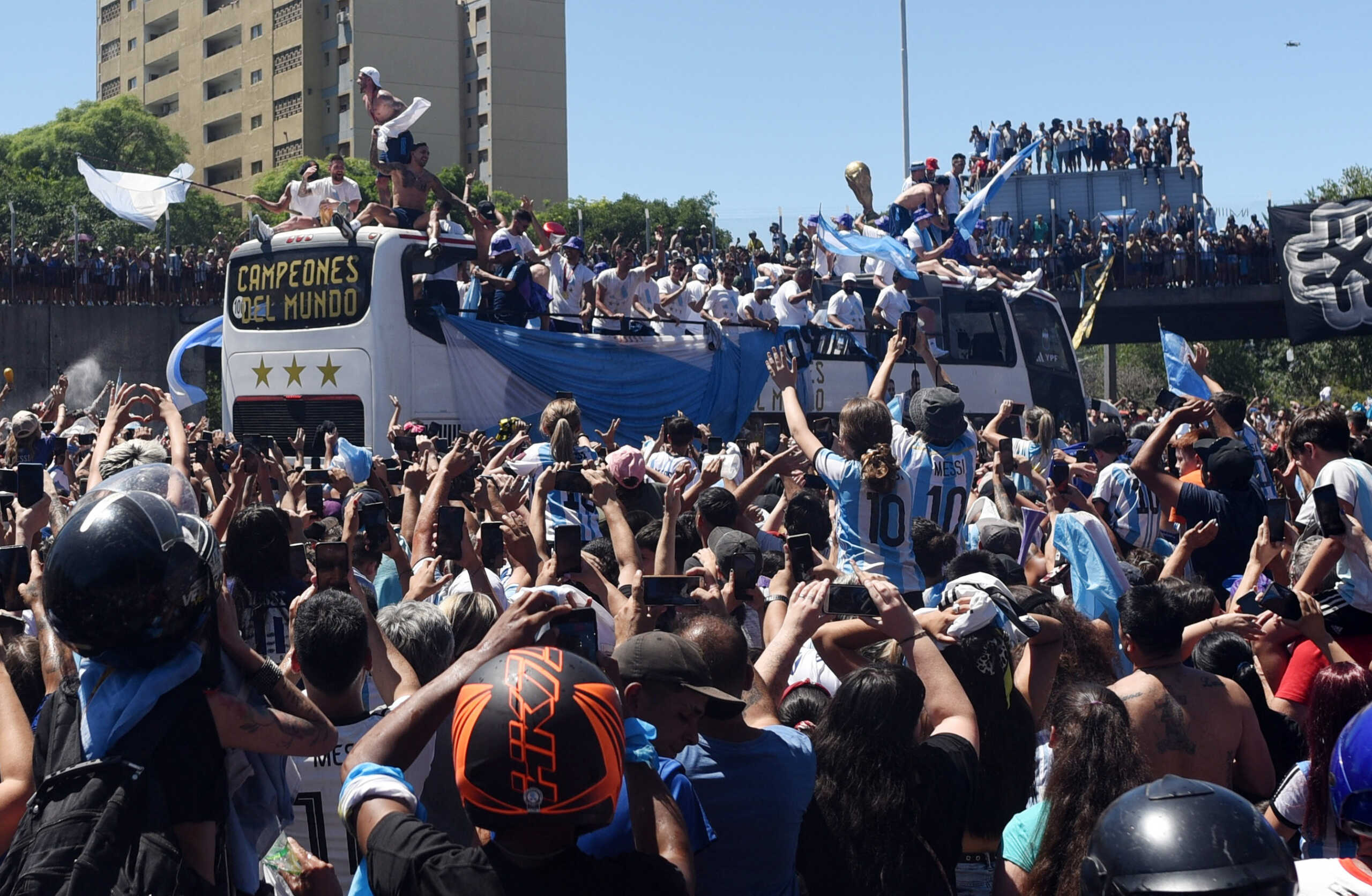 Soccer Football - FIFA World Cup Qatar 2022 - Argentina Victory Parade after winning the World Cup - Buenos Aires, Argentina - December 20, 2022  Argentina fans celebrate as the the bus carrying the players and the World Cup trophy is seen during the victory parade REUTERS
