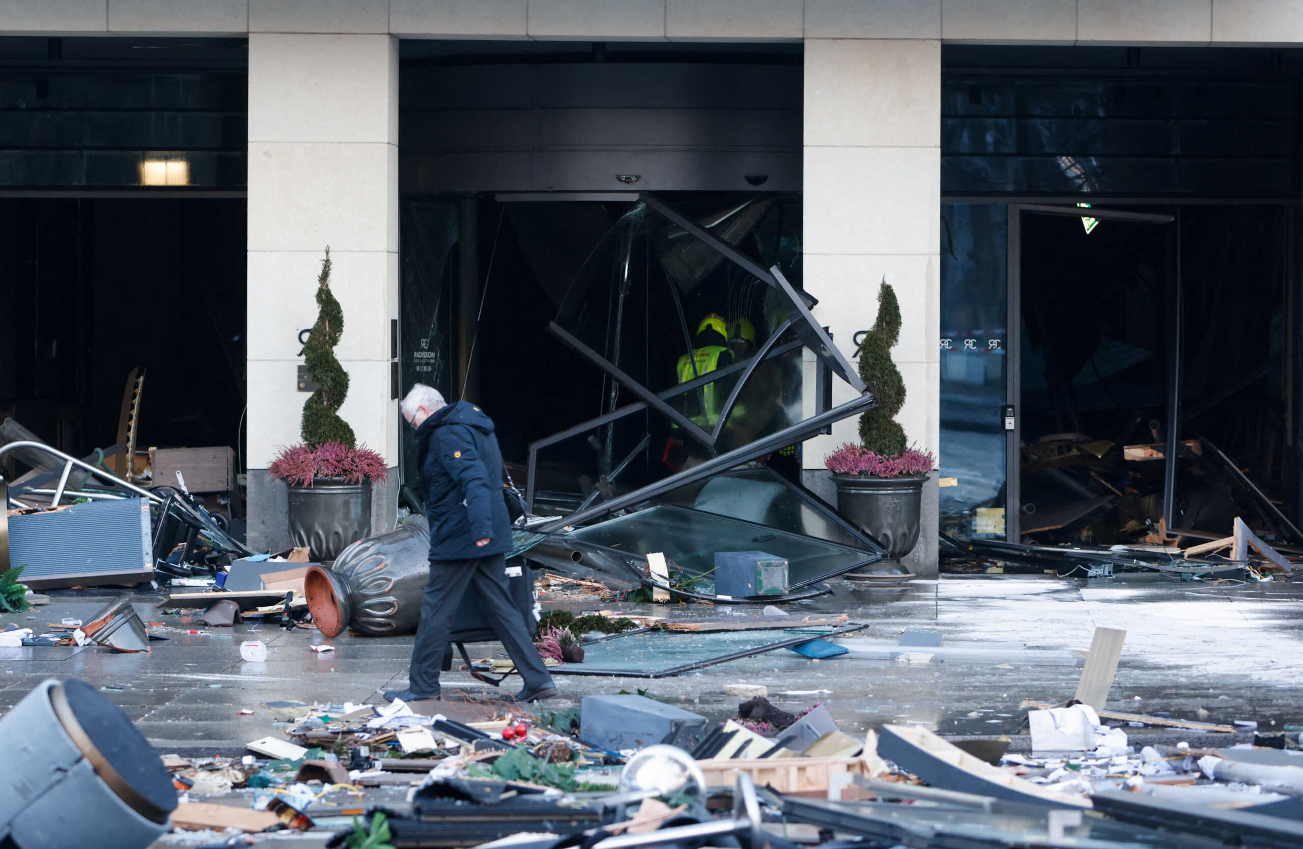 A man walks next to a hotel after a leak of the AquaDom aquarium in central Berlin near Alexanderplatz, Germany, December 16, 2022. REUTERS