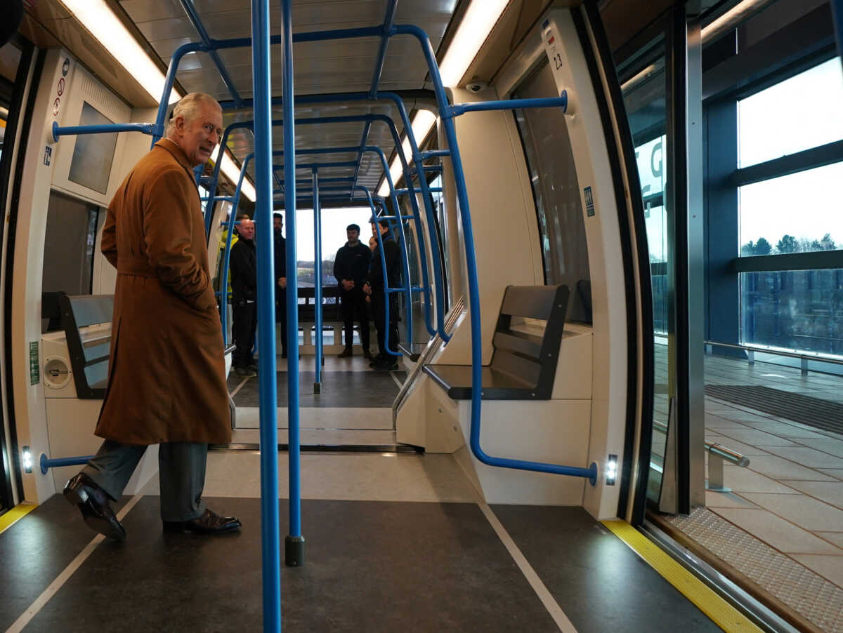 Britain's King Charles travels in a DART carriage for the three-minute journey to the Luton DART central terminal, during a visit to Luton DART Parkway Station to learn about the new cable-drawn mass passenger transit system which will connect Luton Airport Parkway rail station to London Luton Airport, in Luton, Britain December 6, 2022. Yui Mok