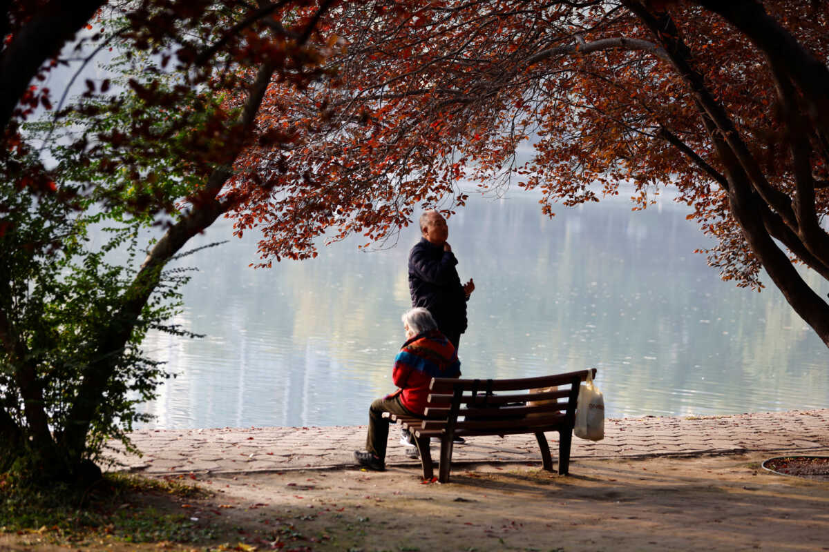 Elderly people rest by a lake at a park in Beijing, China November 10, 2022. REUTERS