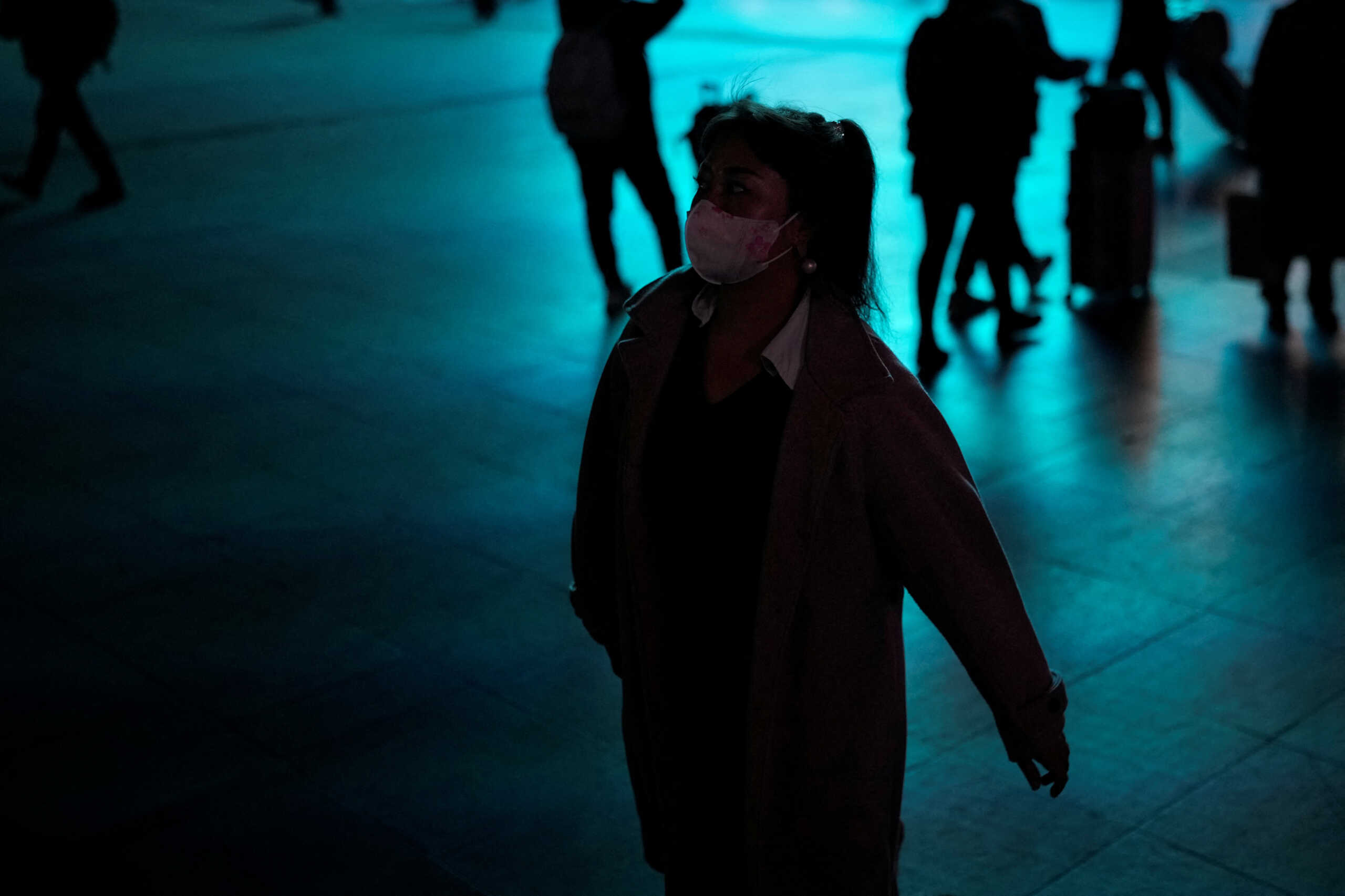 A woman wearing a protective mask walks outside the Shanghai Railway Station, as coronavirus disease (COVID-19) outbreaks continue in Shanghai, China, December 13, 2022. REUTERS