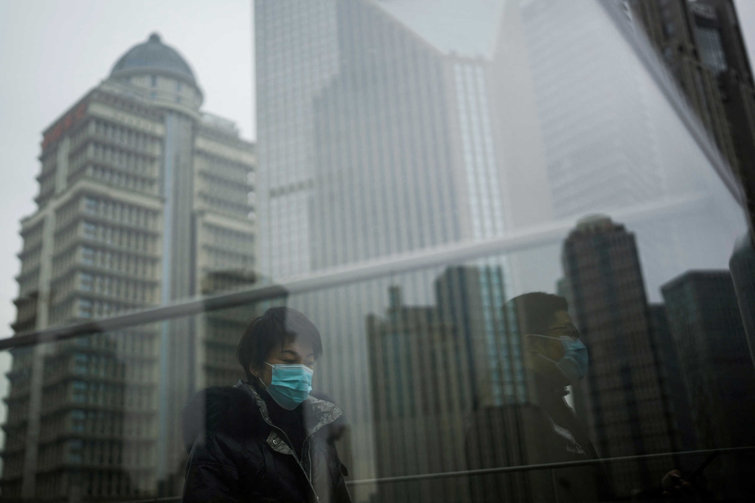 People wearing face masks walk at Lujiazui financial district, as the coronavirus disease (COVID-19) outbreak continues, in Shanghai, China, December 9, 2022. REUTERS