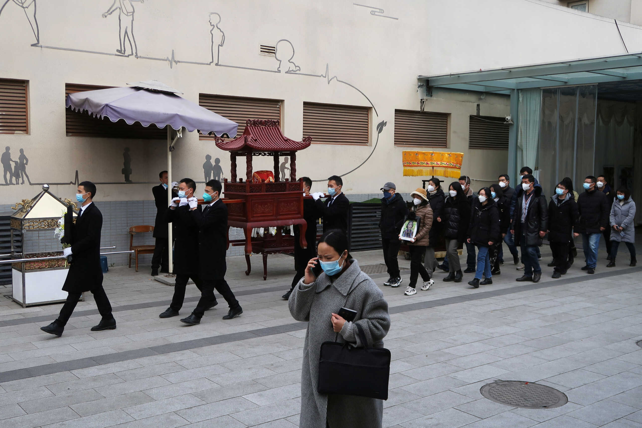 Staff members carry an urn for a funeral procession outside a crematorium of a funeral home, amid the coronavirus disease (COVID-19) outbreak in Chengdu, Sichuan province, China December 28, 2022. REUTERS