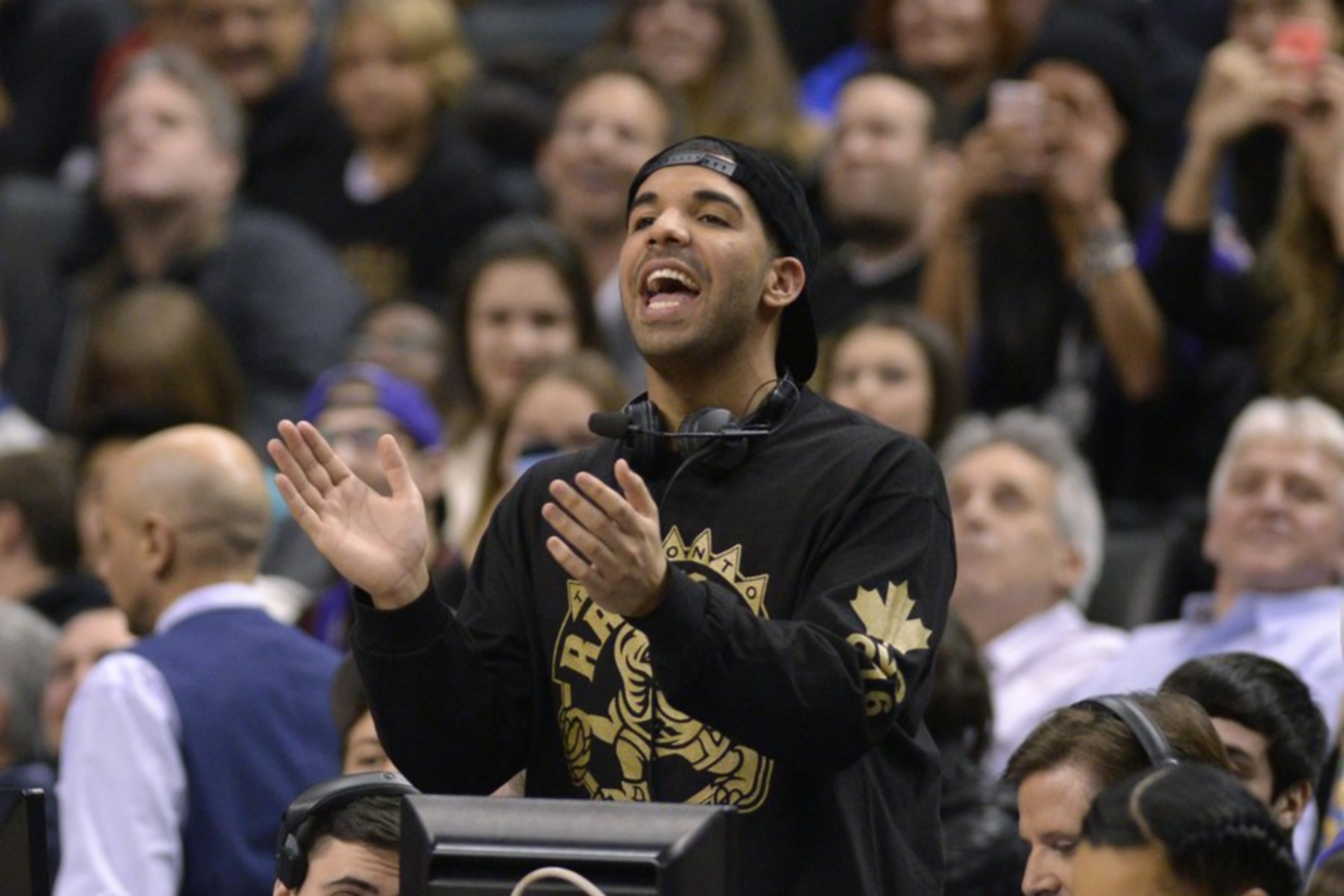 epa04015997 Canadian rapper Aubrey Drake Graham, and the ambassador for the Toronto Raptors, watches the Raptors playing the Brooklyn Nets in the first half of their NBA game at Air Canada Centre in Toronto, Canada, 11 January 2014.  EPA