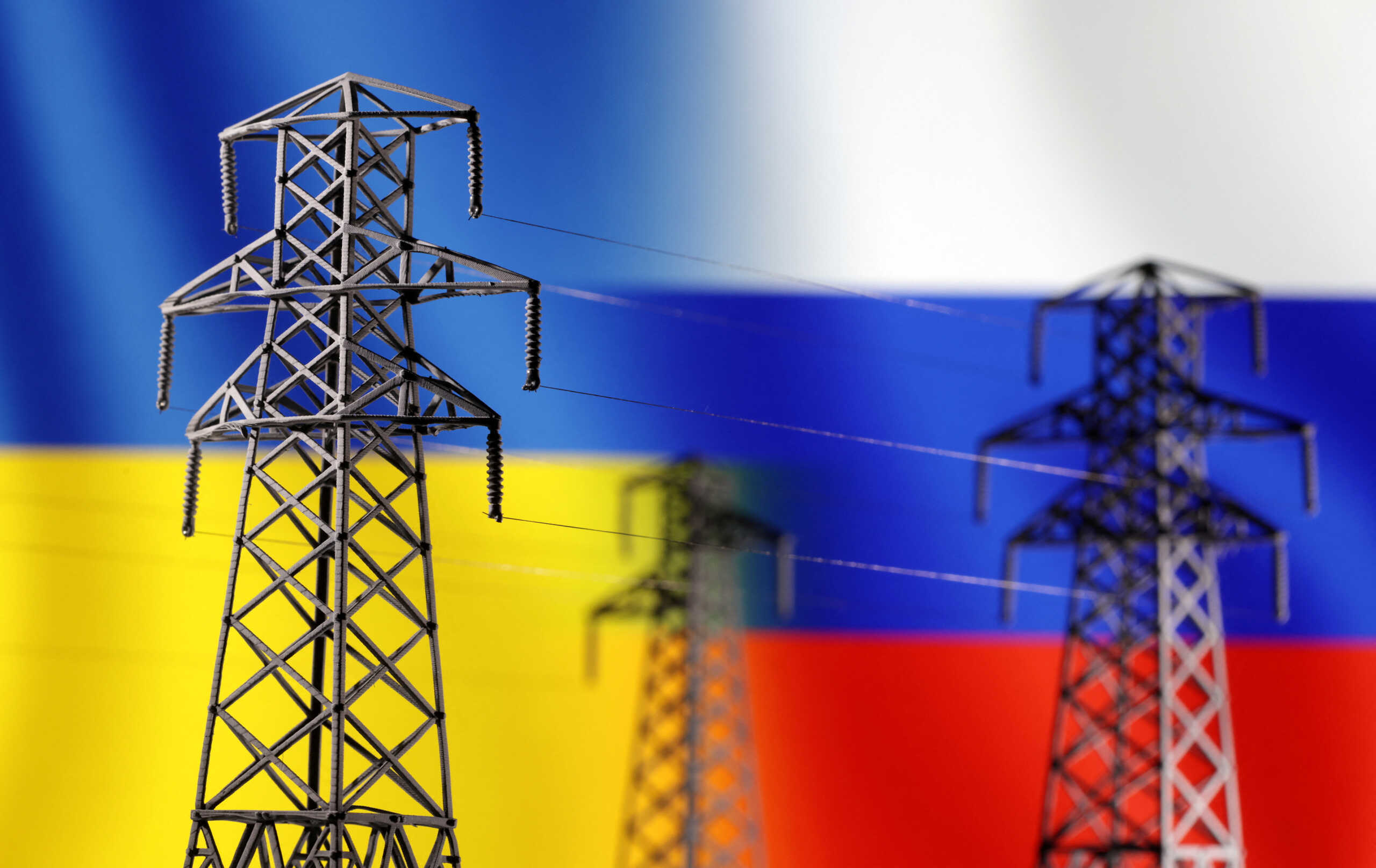 Electric power transmission miniatures are seen in front of displayed Ukrainian and Russian flags in this illustration taken, December 5, 2022. REUTERS