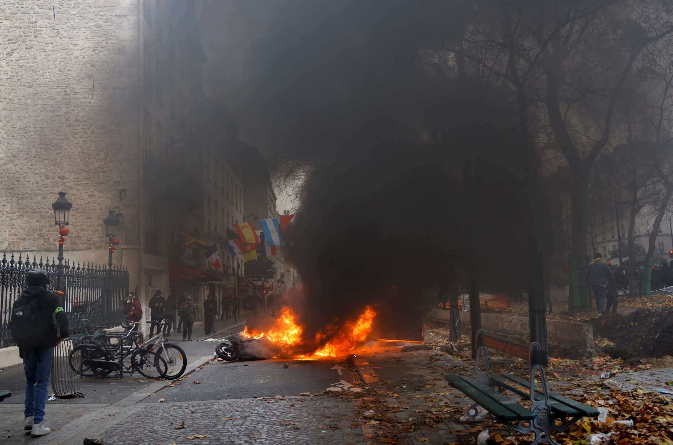 Smoke billows from a fire, as members of the Kurdish community attend a demonstration, following a shooting, in Paris, France December 24, 2022. REUTERS